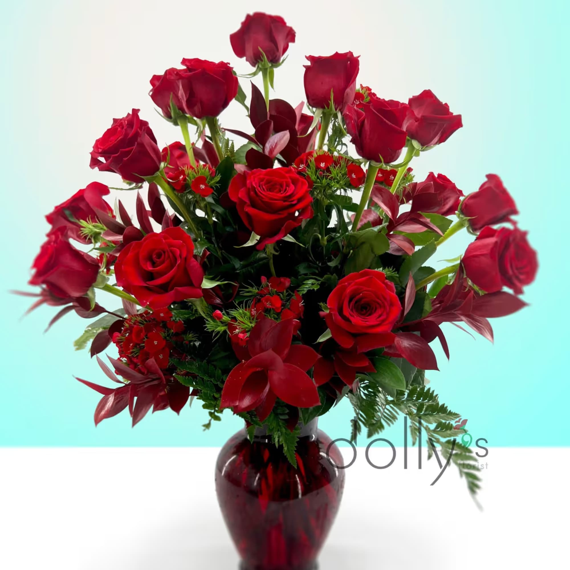 Twelve long-stem red roses gathered in a lush, rounded bouquet make a