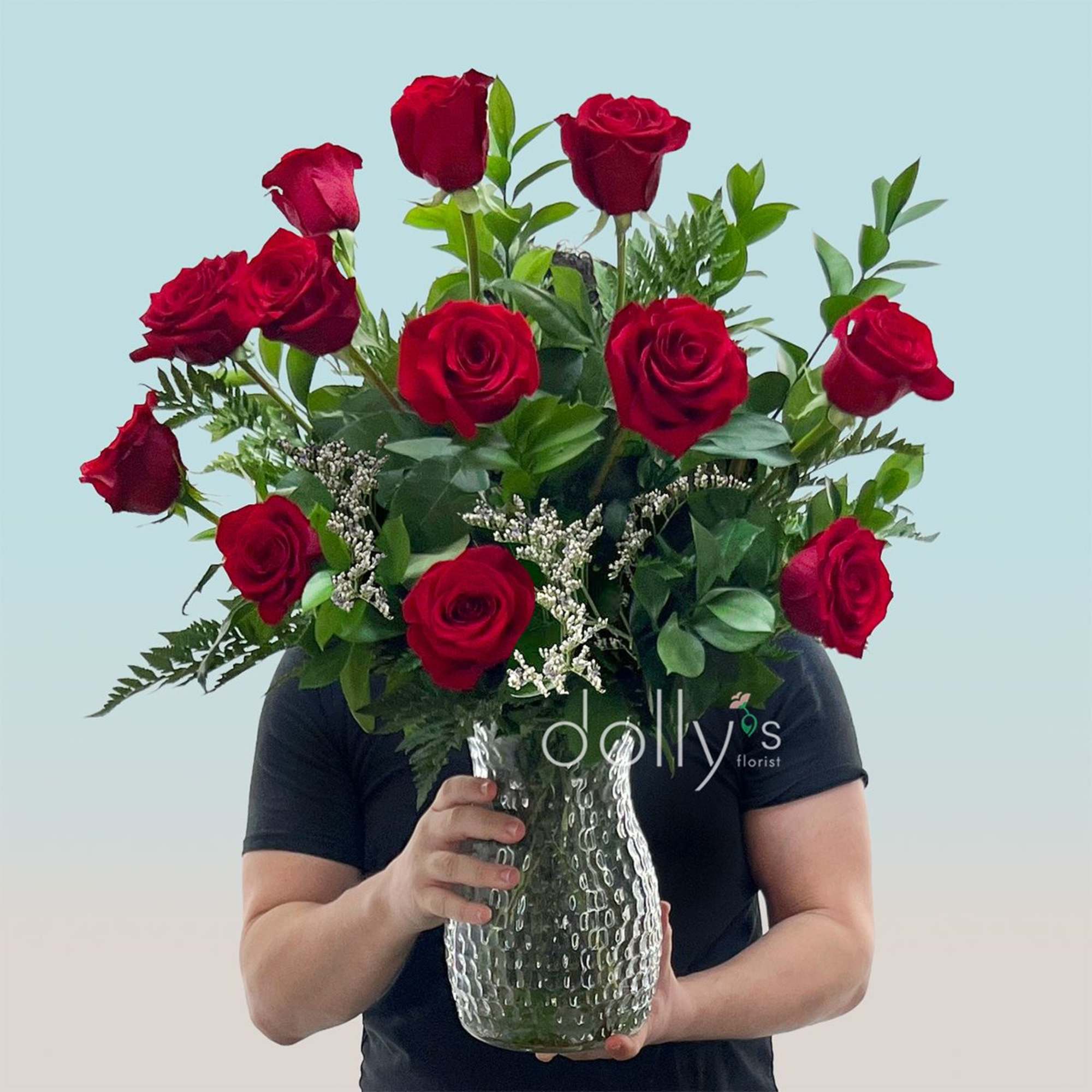 Twelve long-stem red roses gathered in a lush, rounded bouquet make a