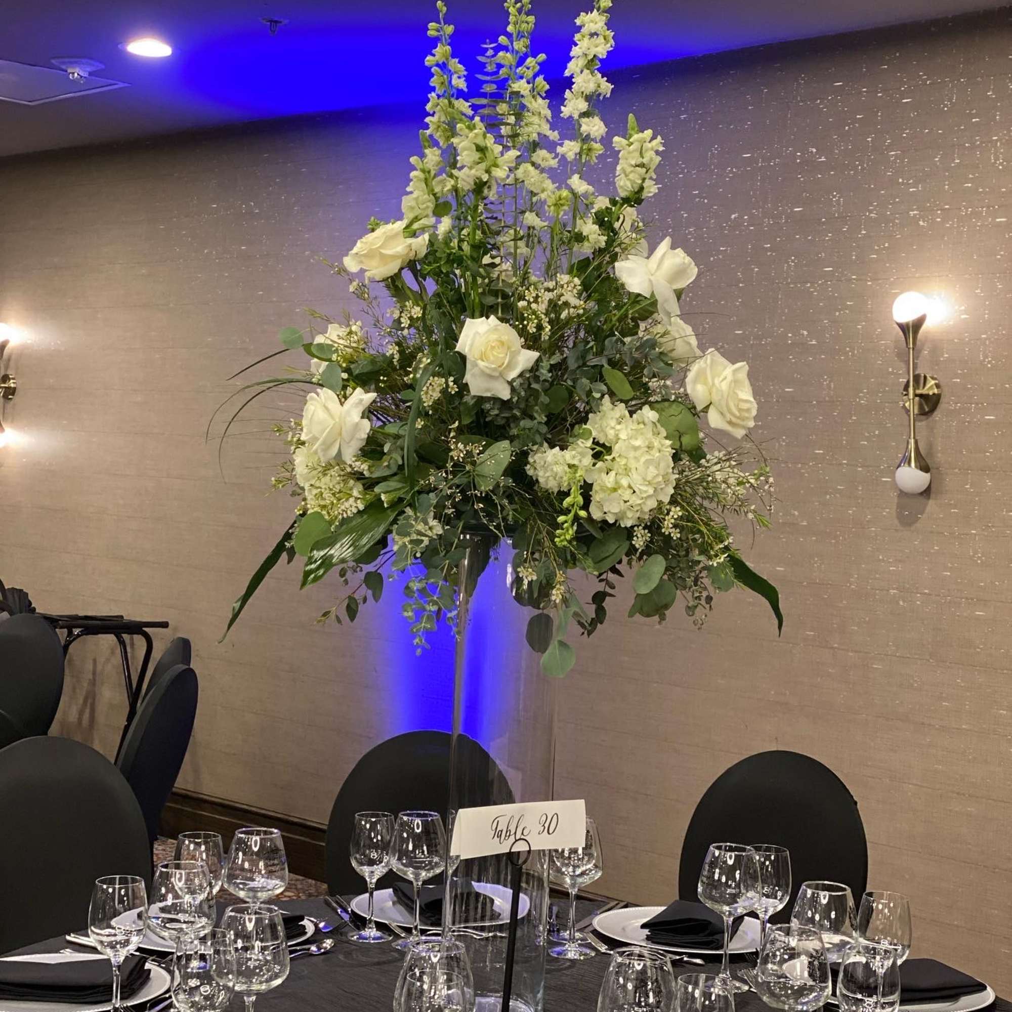 Tall white floral centerpiece on a banquet table