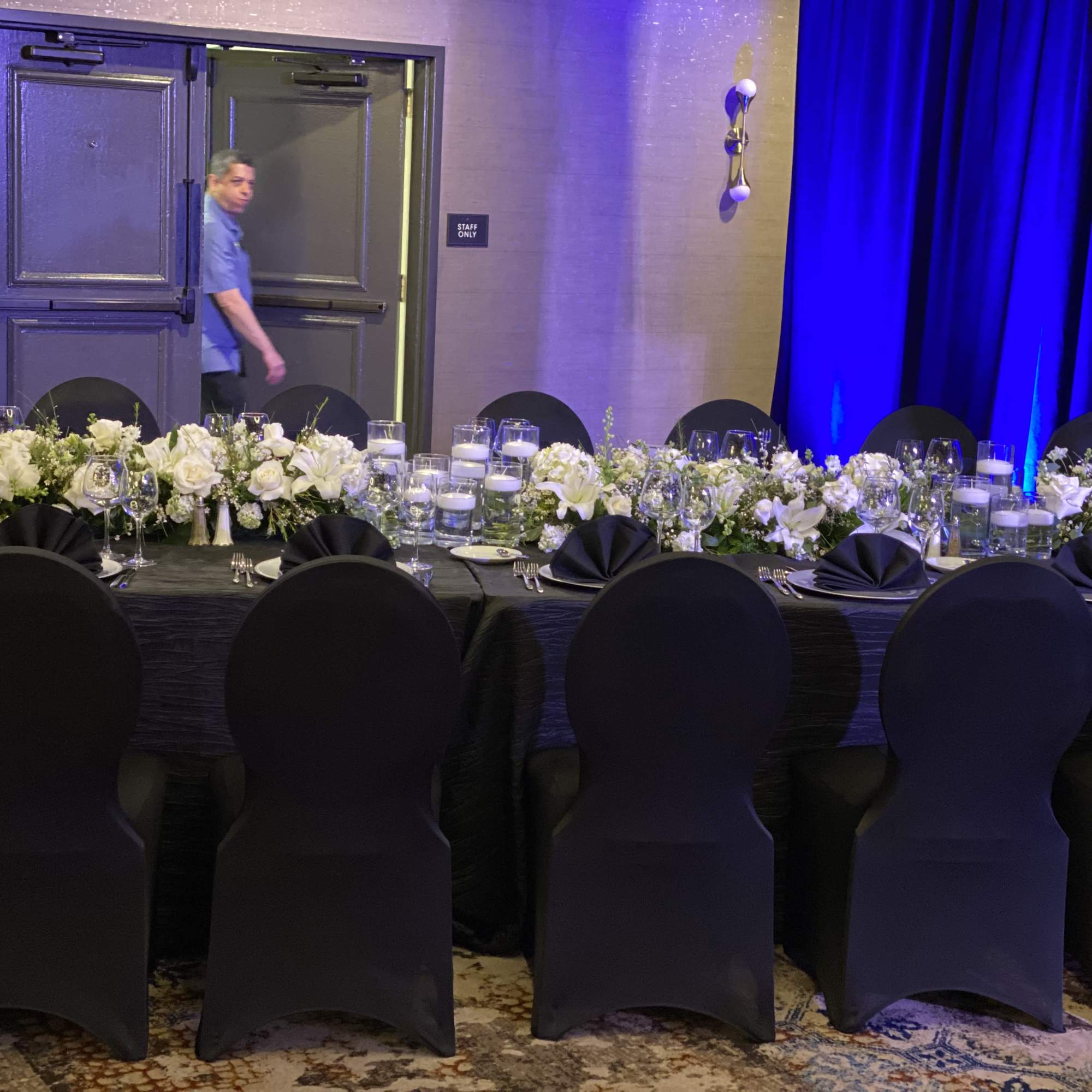 Long banquet table with white floral centerpieces and candles