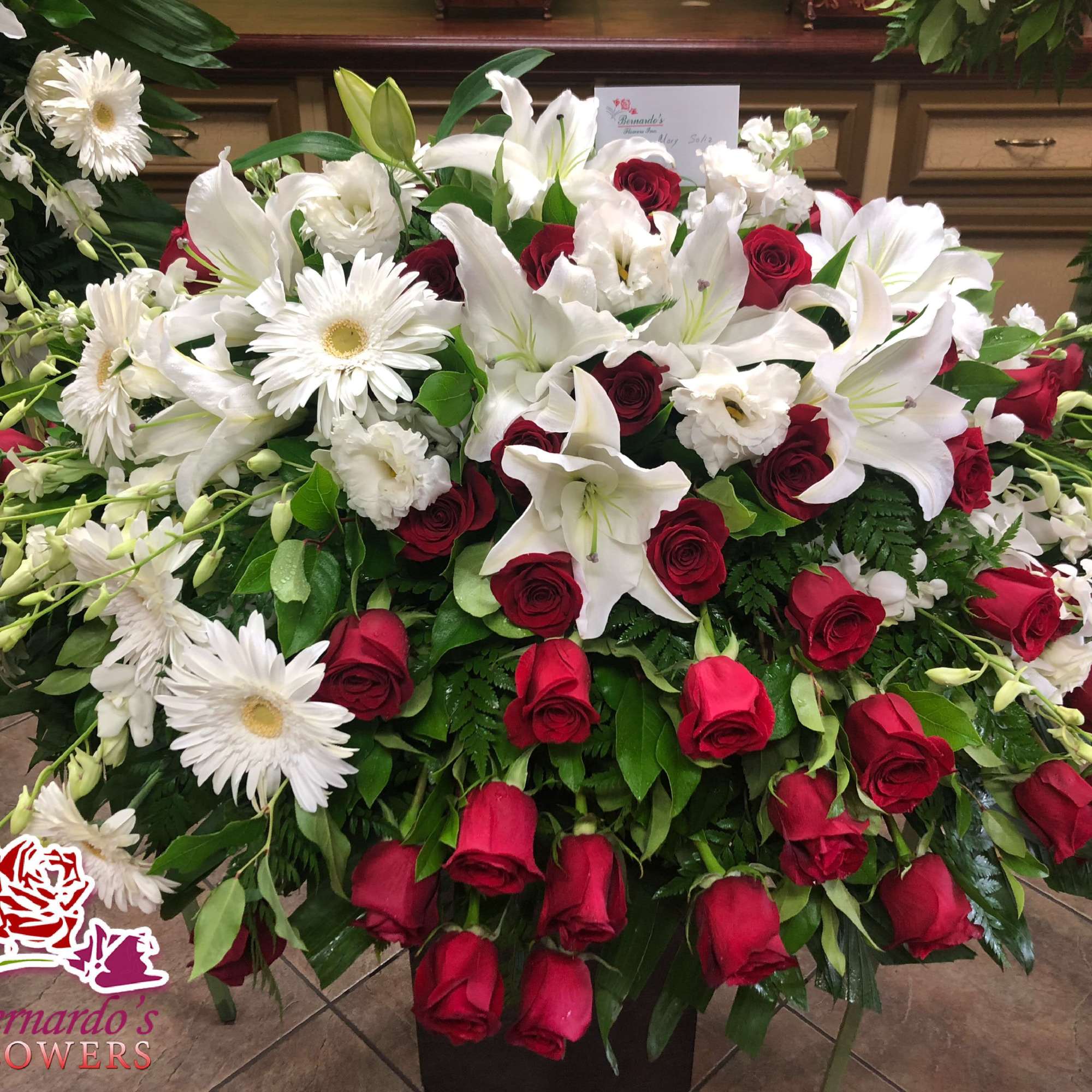 Large floral spray with white lilies, red roses, and white daisies