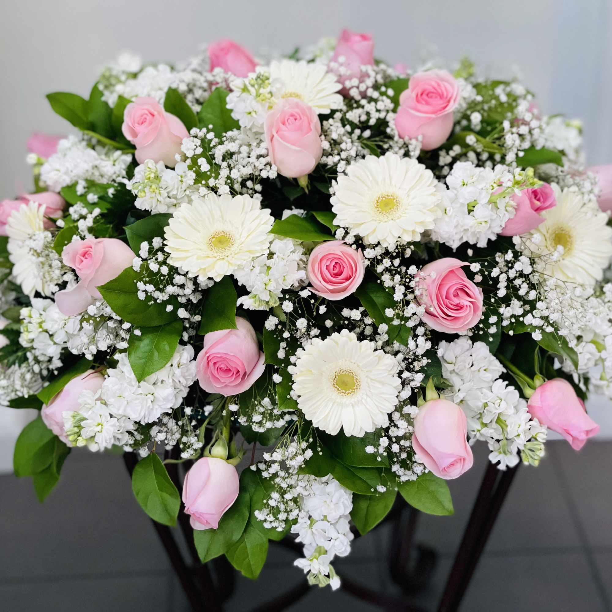 Pink roses and white daisies in a low floral arrangement