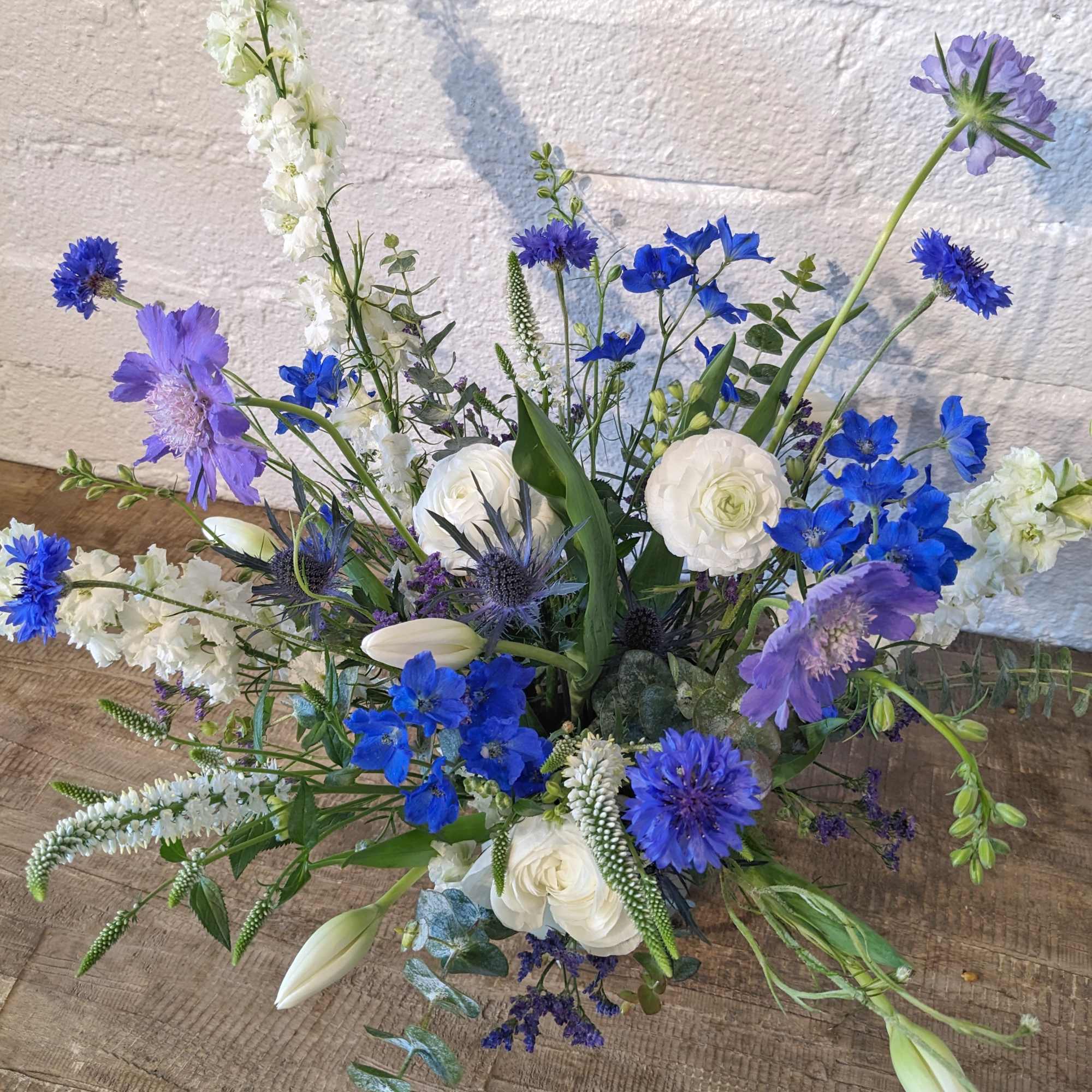 Blue and white mixed flower arrangement with tall stems and open blooms