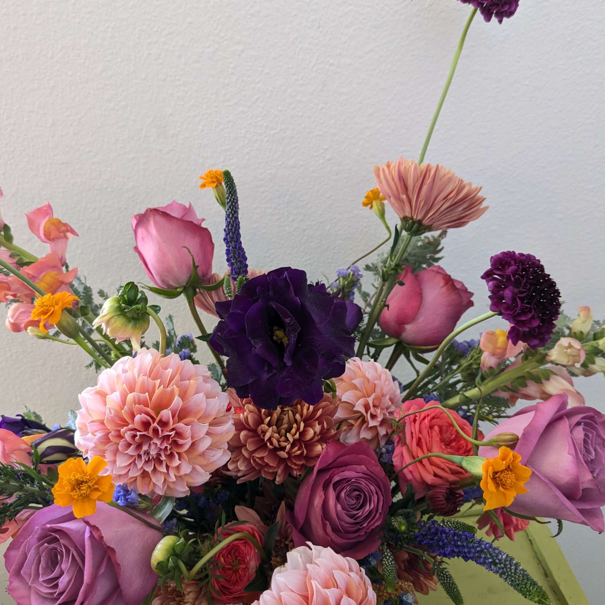 Mixed bouquet with purple and pink roses, dahlias, and small accent flowers