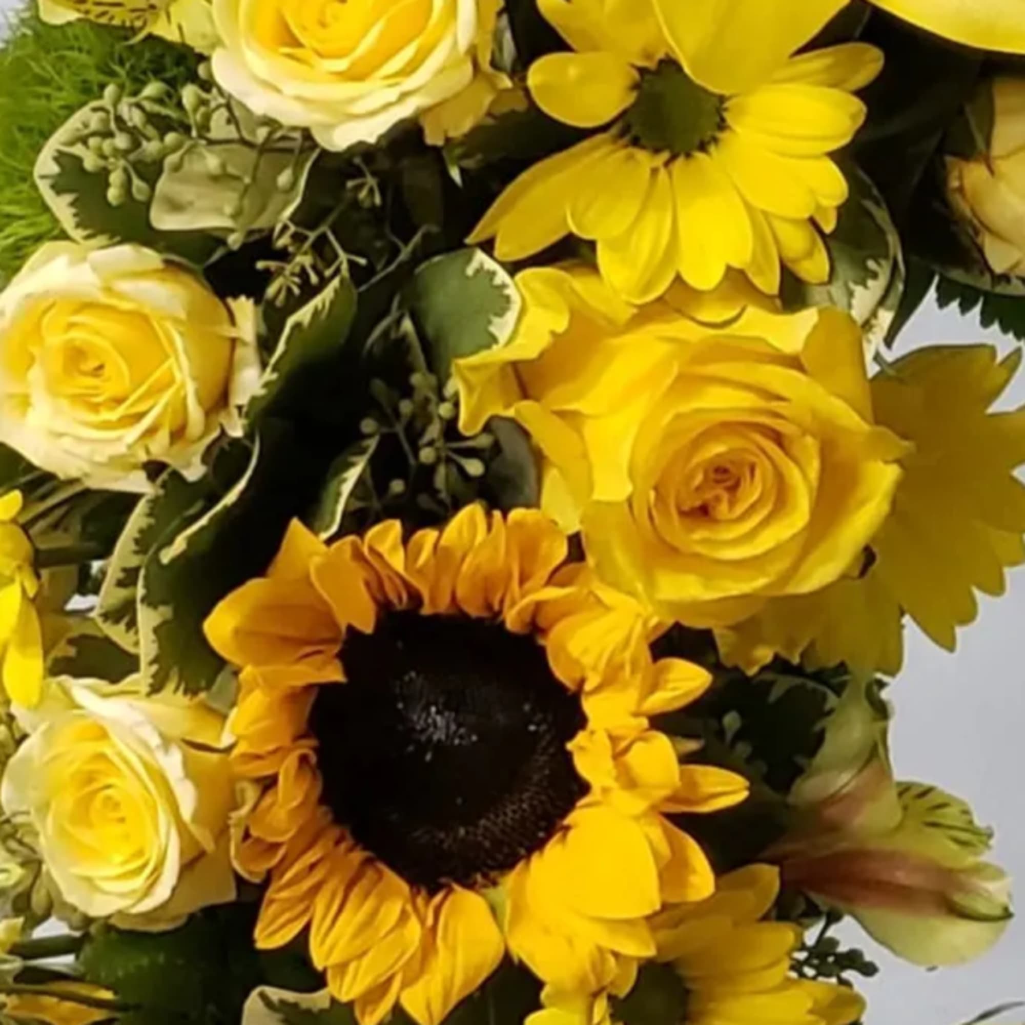 Yellow bouquet with roses, sunflowers, and daisies