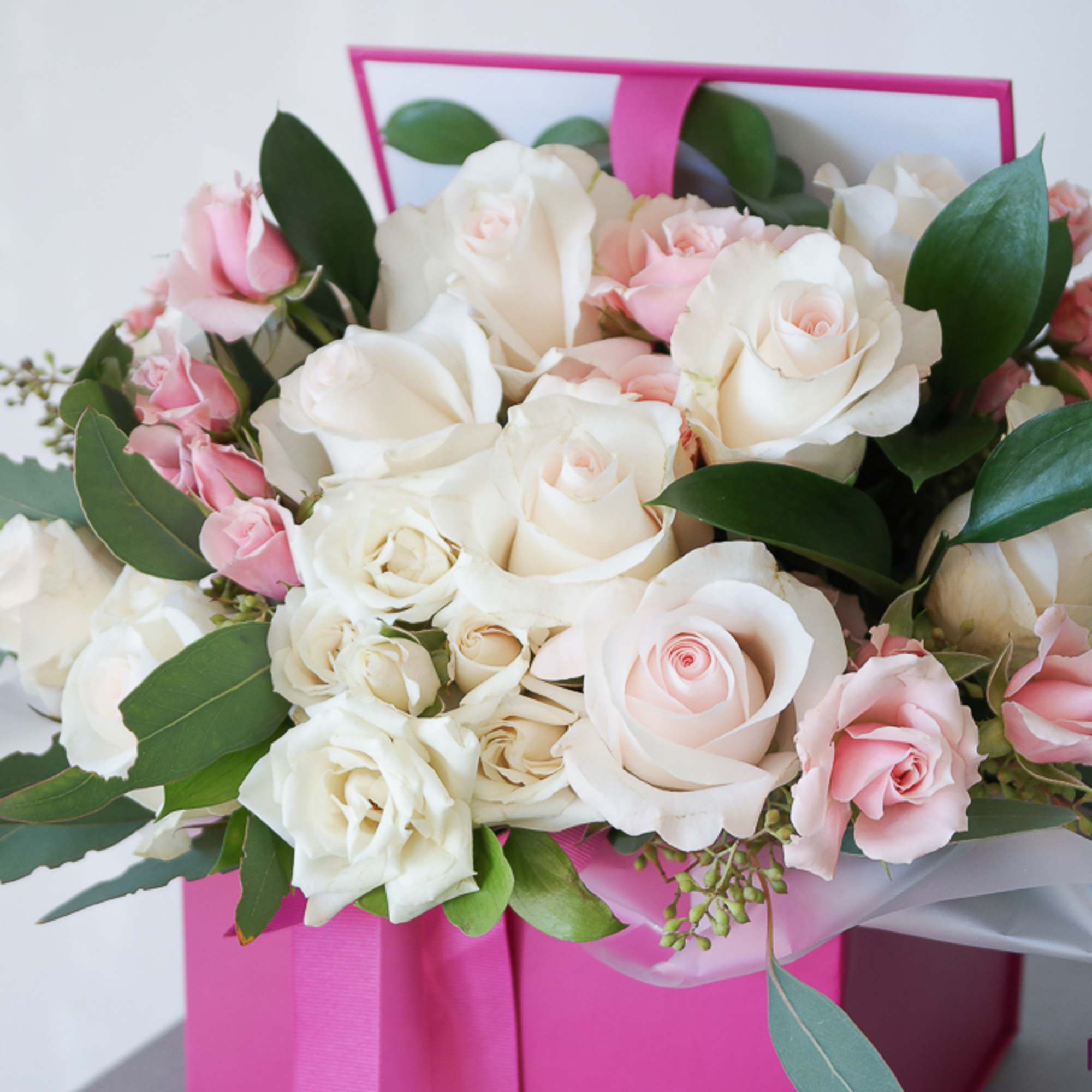 Bouquet of white and pink roses in a pink gift box