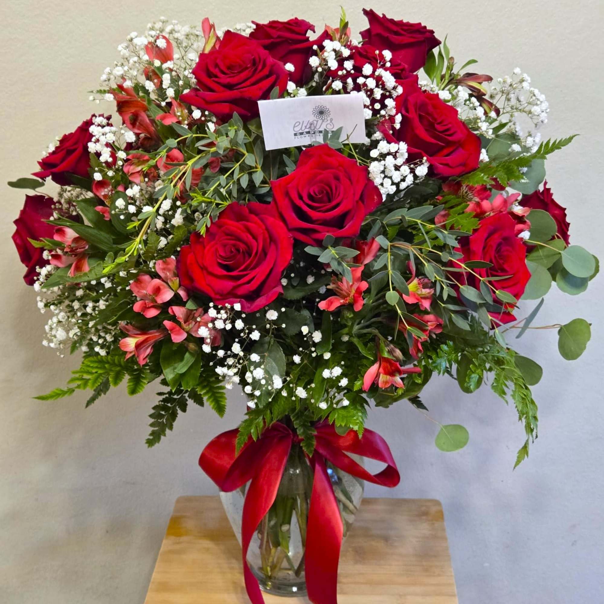 Bouquet of red roses with white baby's breath in a glass vase.