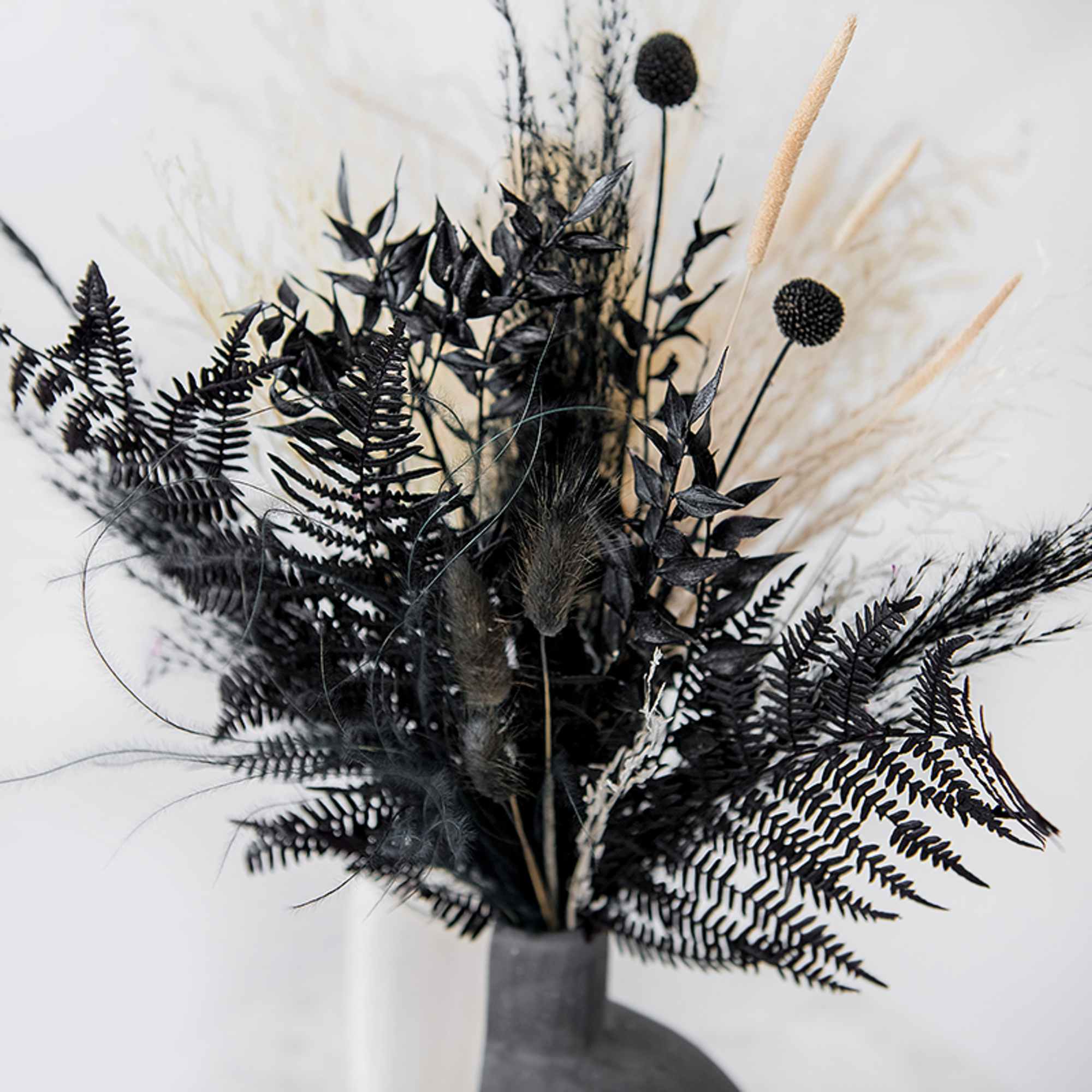 Black dried floral arrangement in a gray vase