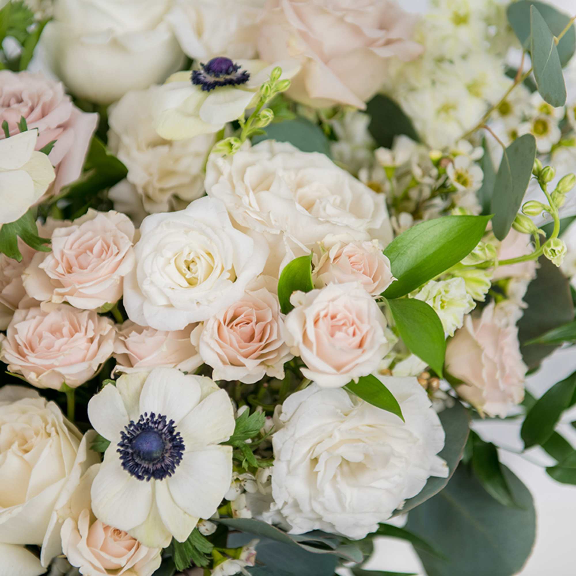 Bouquet of white and blush roses with white anemones