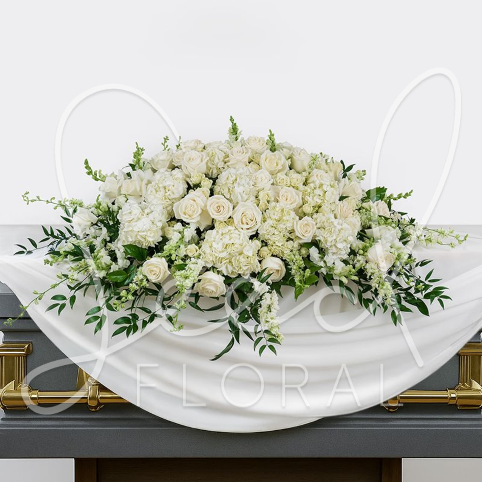 White rose and hydrangea casket spray with trailing greenery