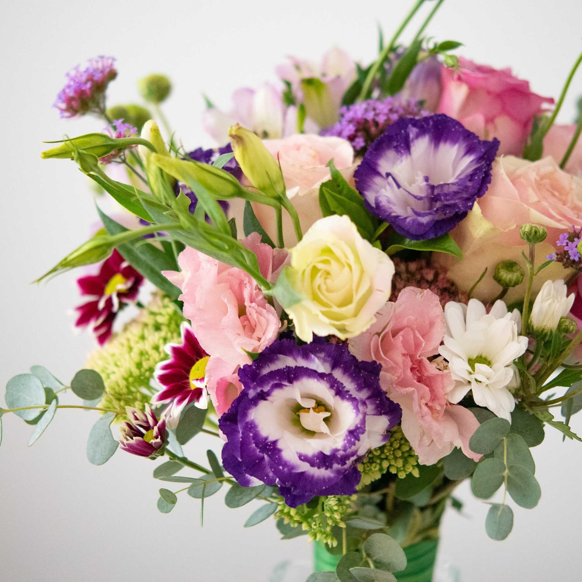 Bouquet of pink, purple, and white flowers with greenery