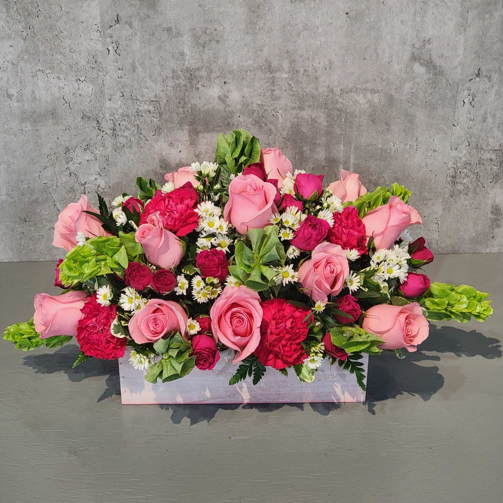 Pink and red rose arrangement in a white rectangular box