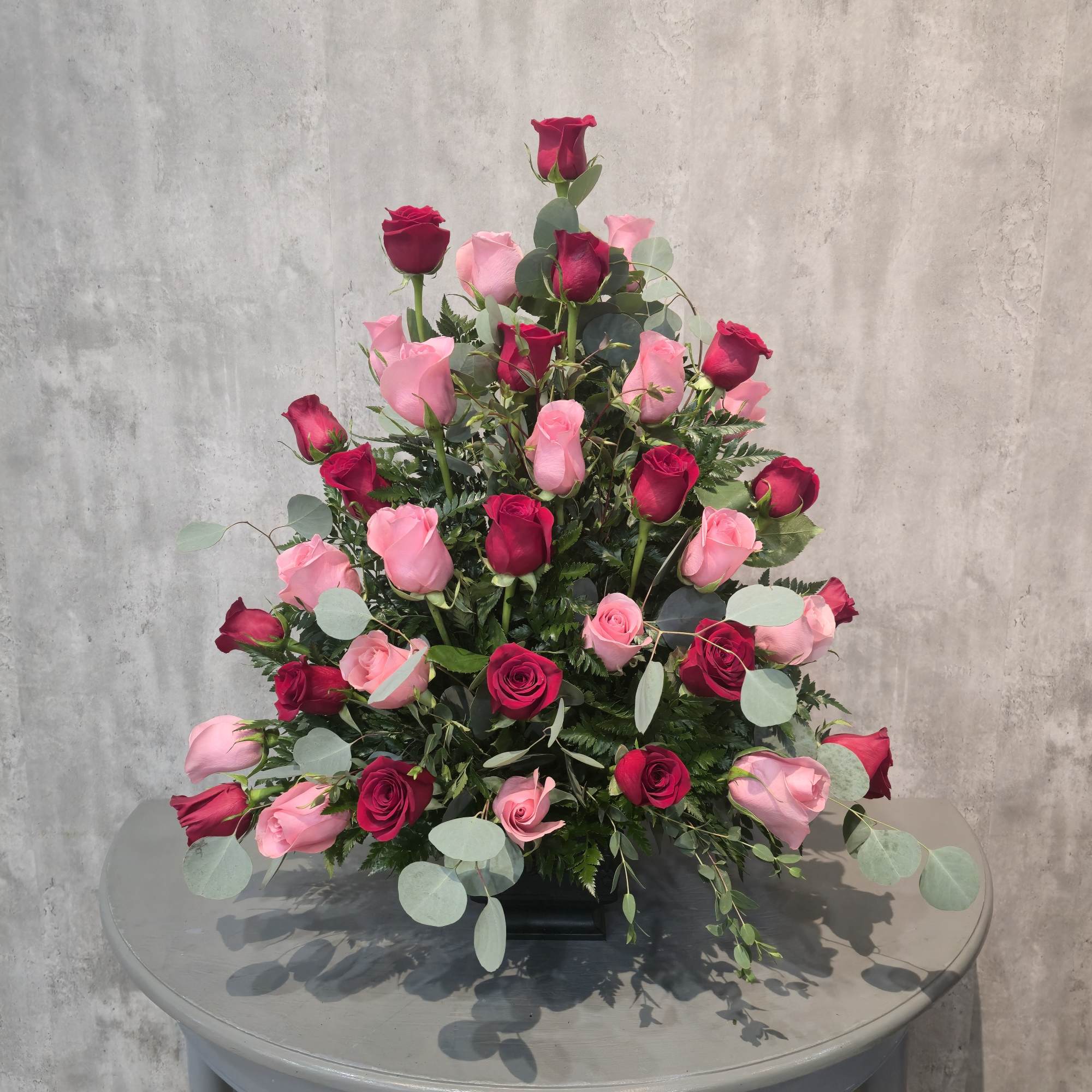 Beautiful roses adorn this series in a casket spray and pedestal arrangement