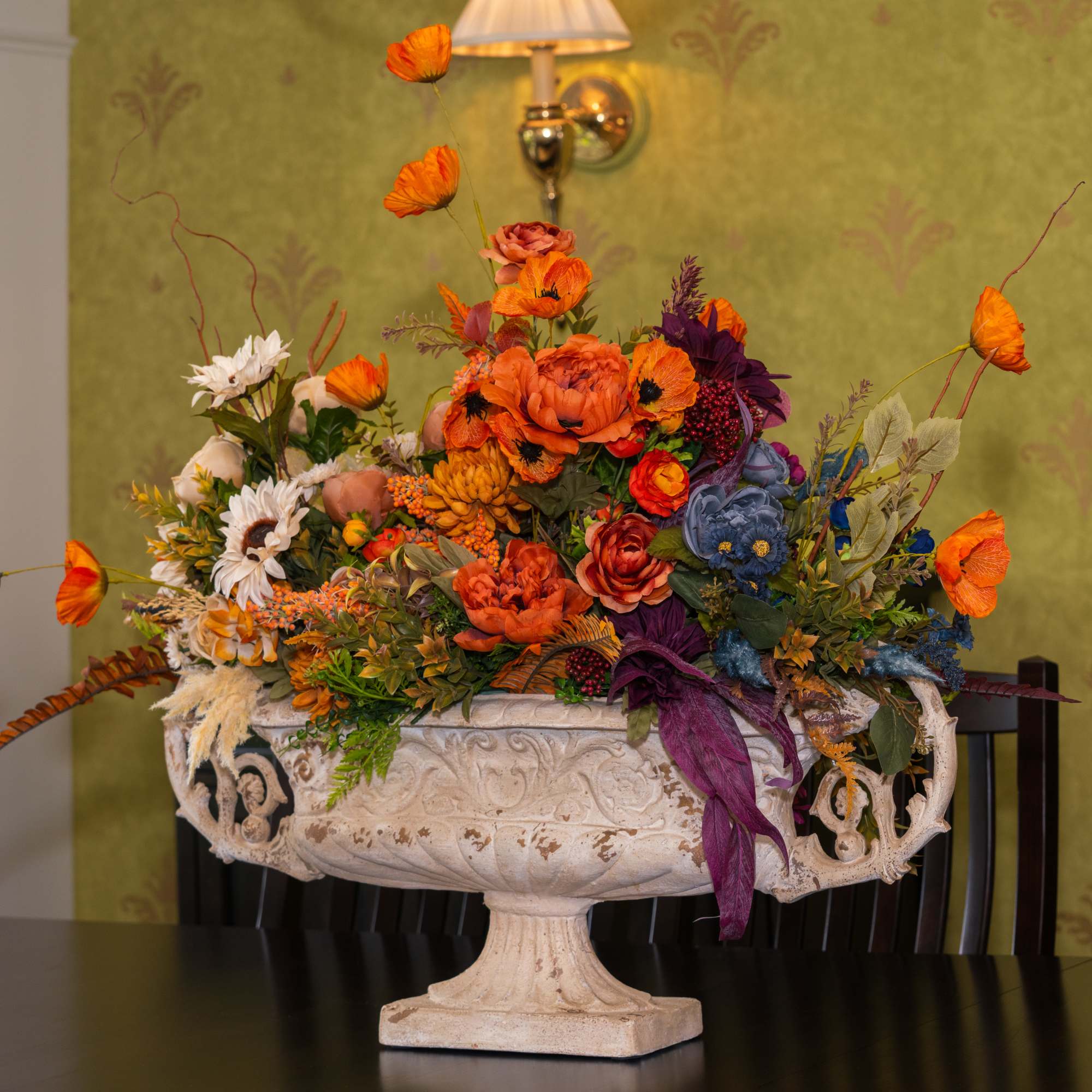 Large autumn floral arrangement in a decorative pedestal urn
