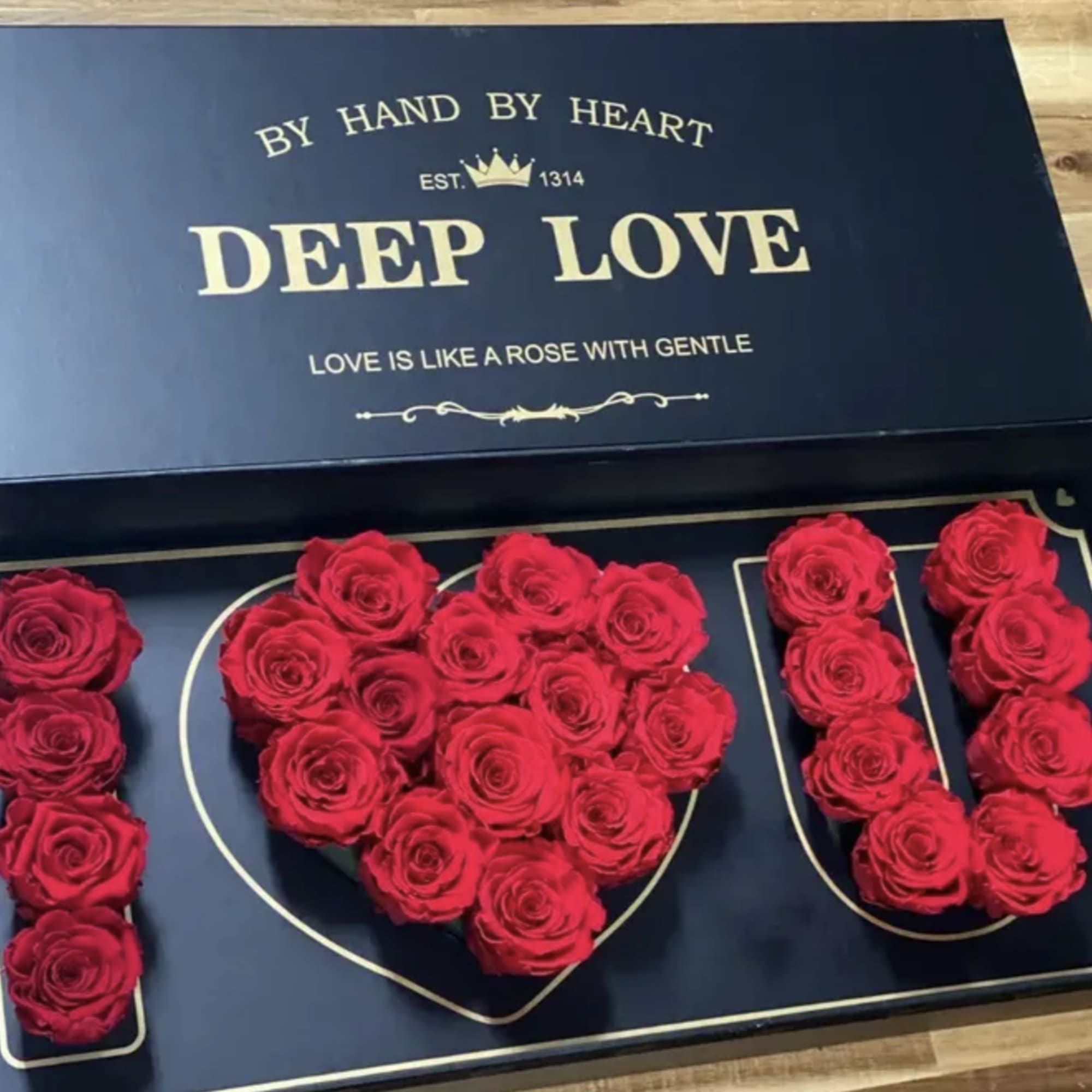 Red roses arranged in a heart-shaped box with matching rose letters