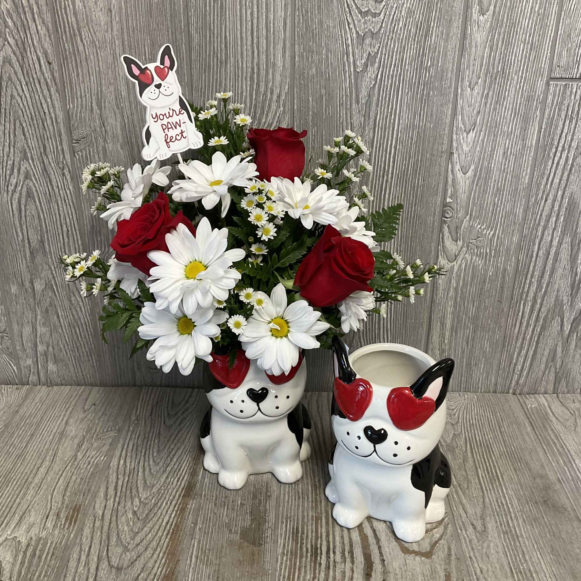 Daisy and red rose arrangement in a dog-shaped container with a matching mug.