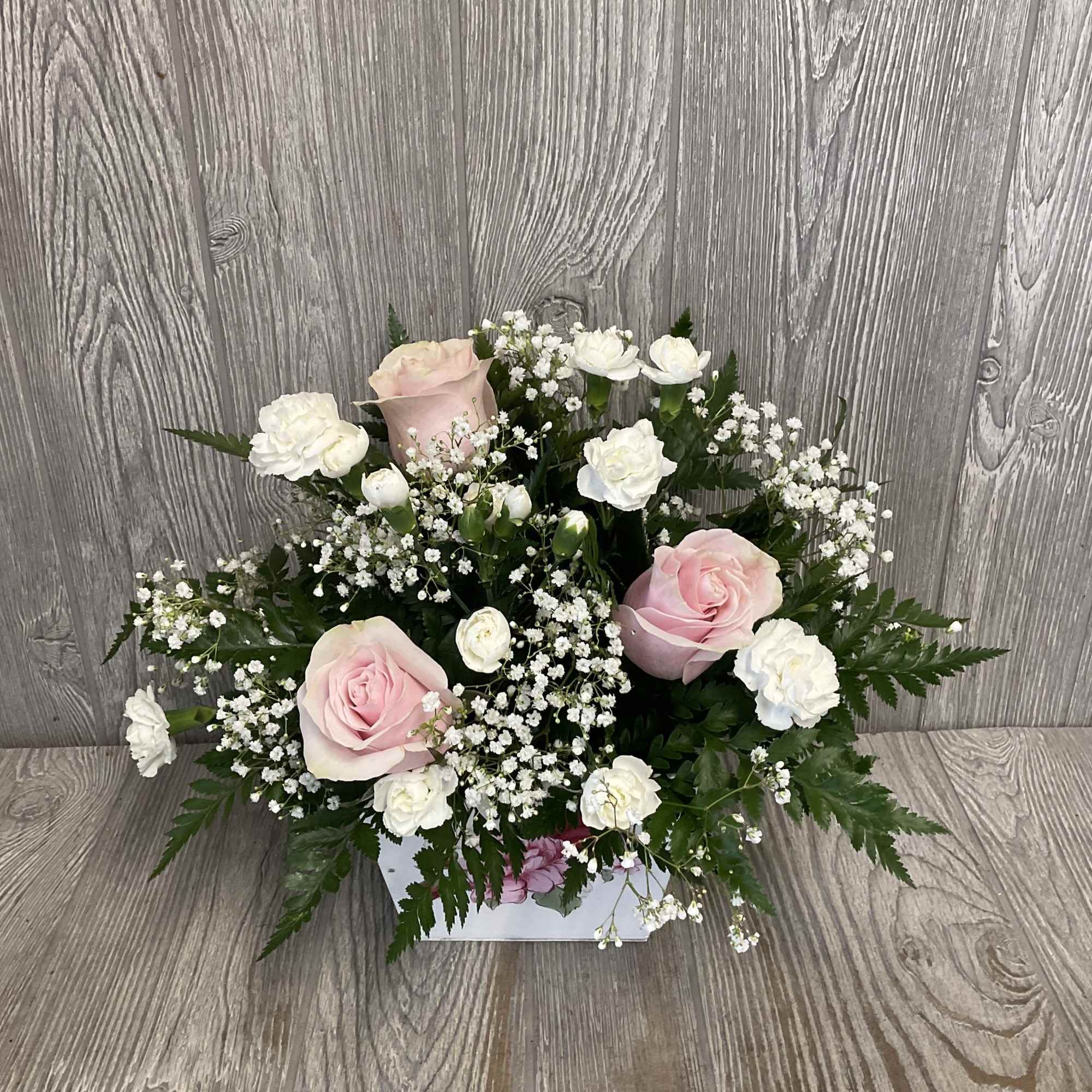 Pink and white rose arrangement in a white box