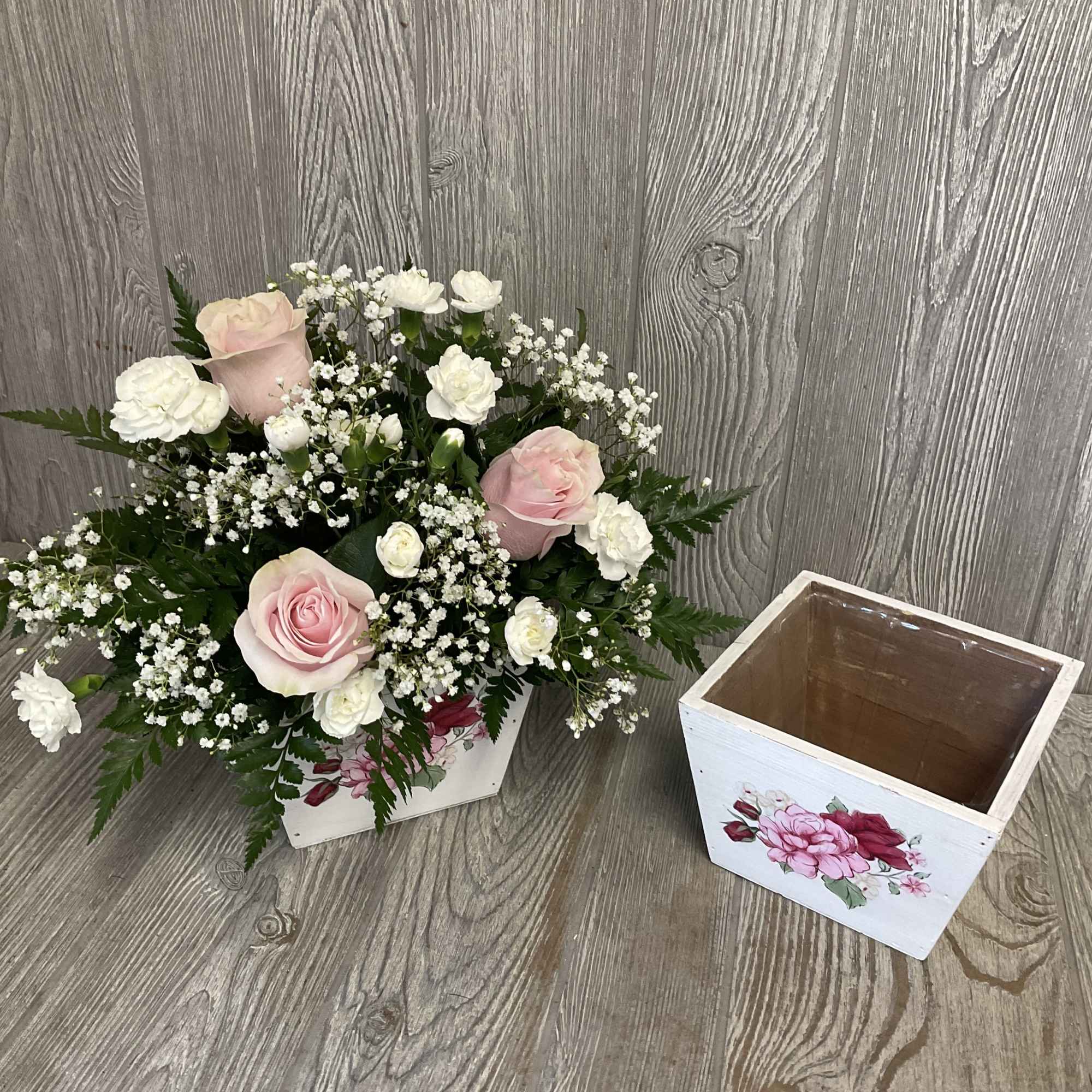 Pink and white roses with baby's breath in a white wooden box