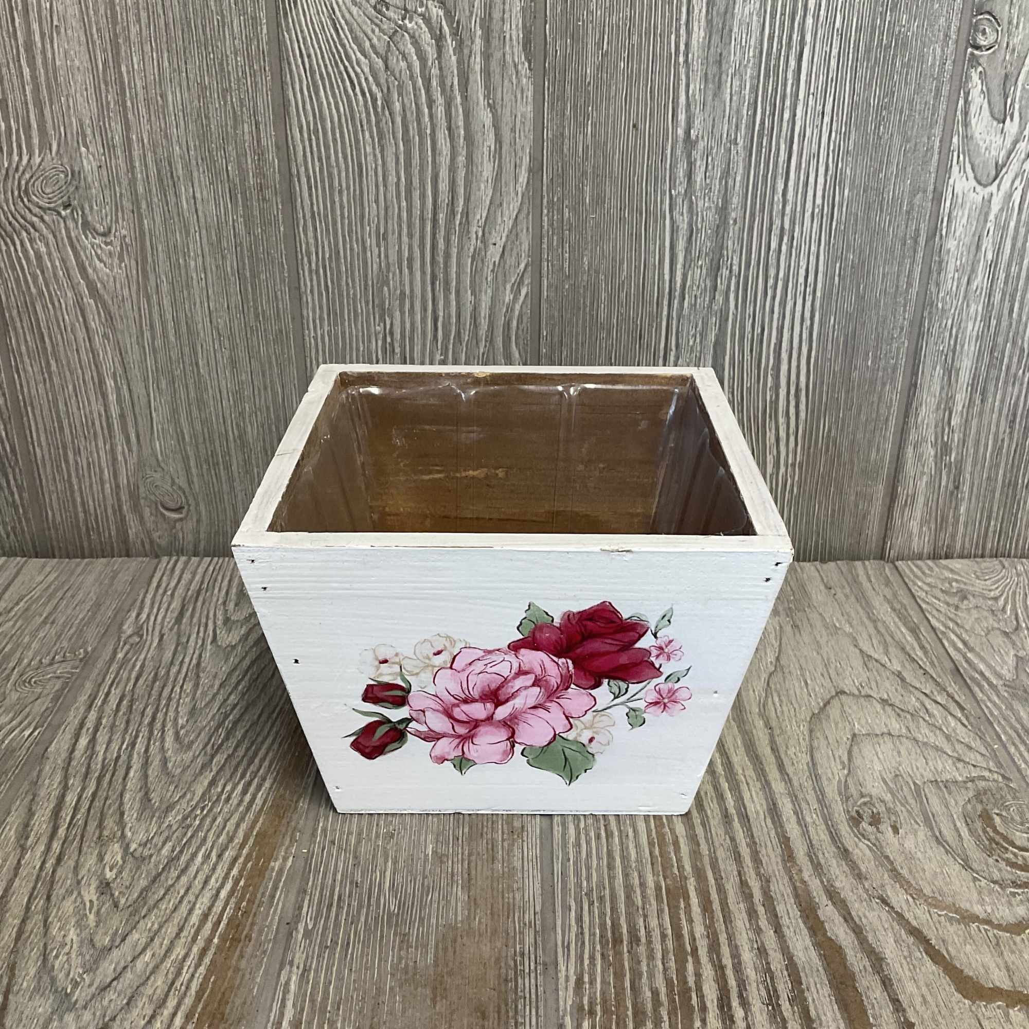White square wooden planter box with painted pink flowers