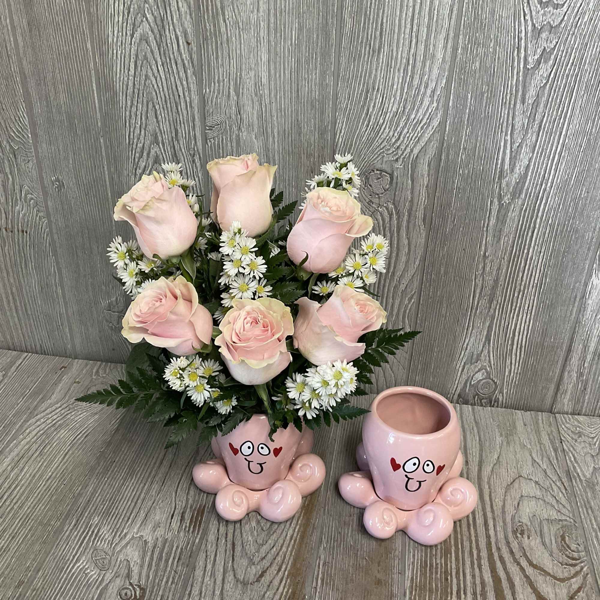 Pink roses and white daisies in a pink cartoon-face mug planter