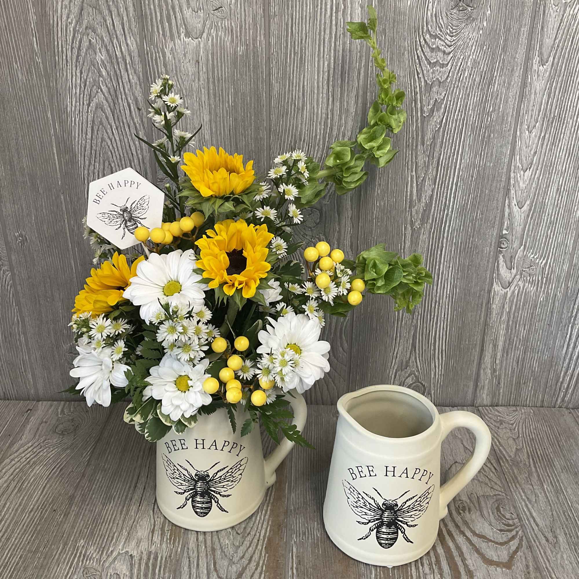 Beautiful arrangement of fresh cut flowers in a keepsake ceramic bee pitcher.