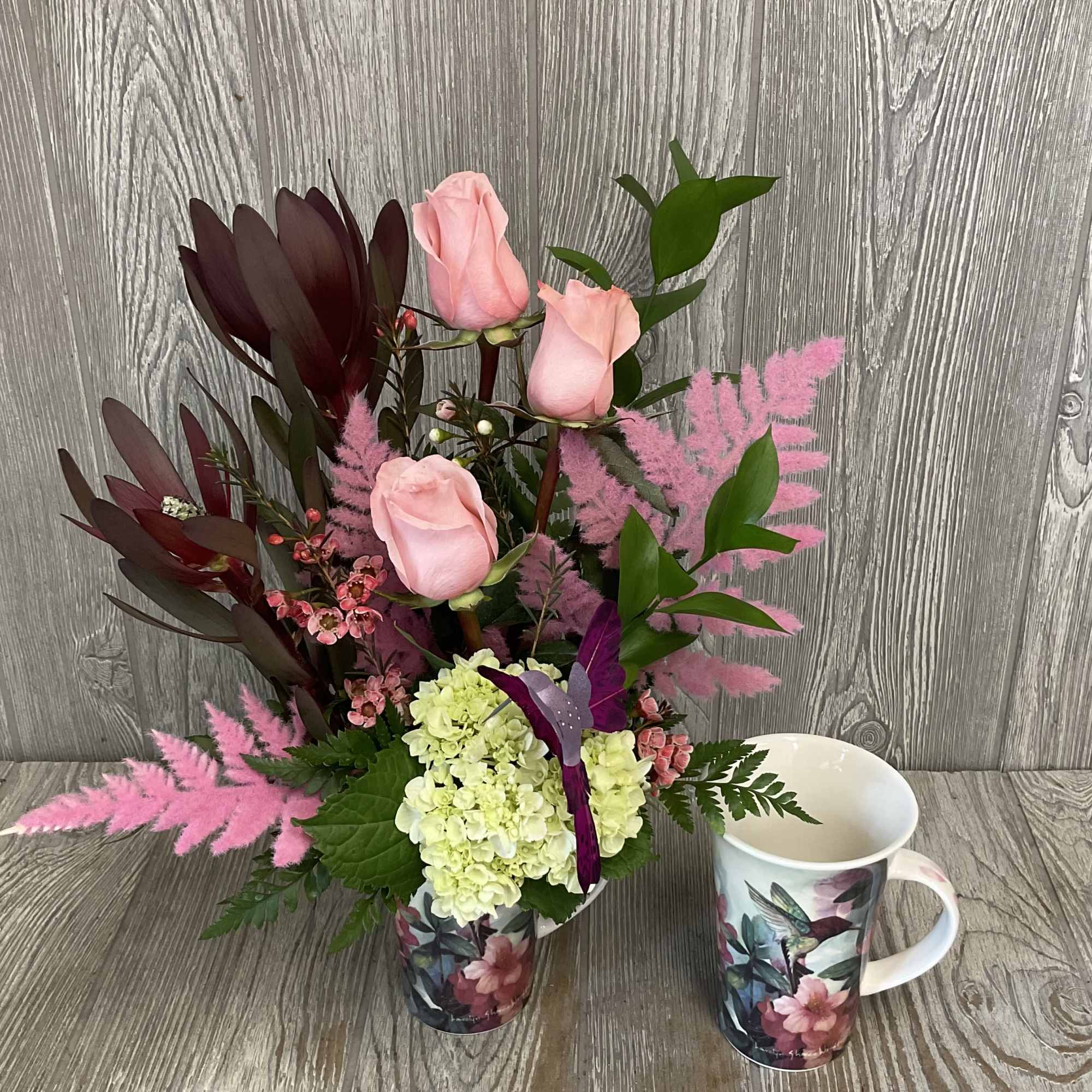 A modern style fresh cut flower arrangement, in a keepsake ceramic hummingbird