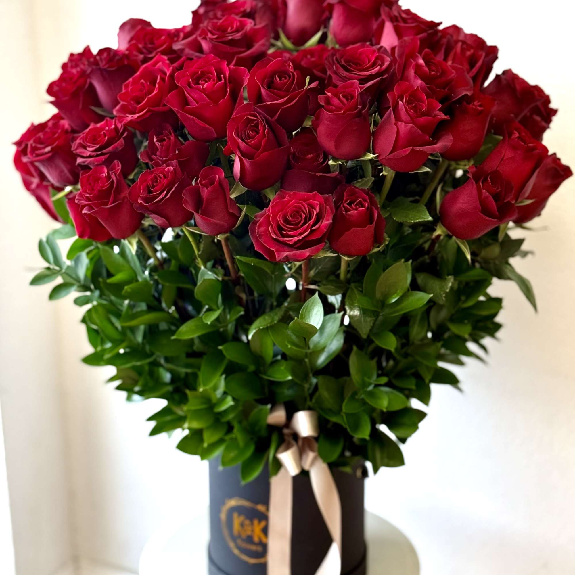Bouquet of red roses in a black hat box with a ribbon