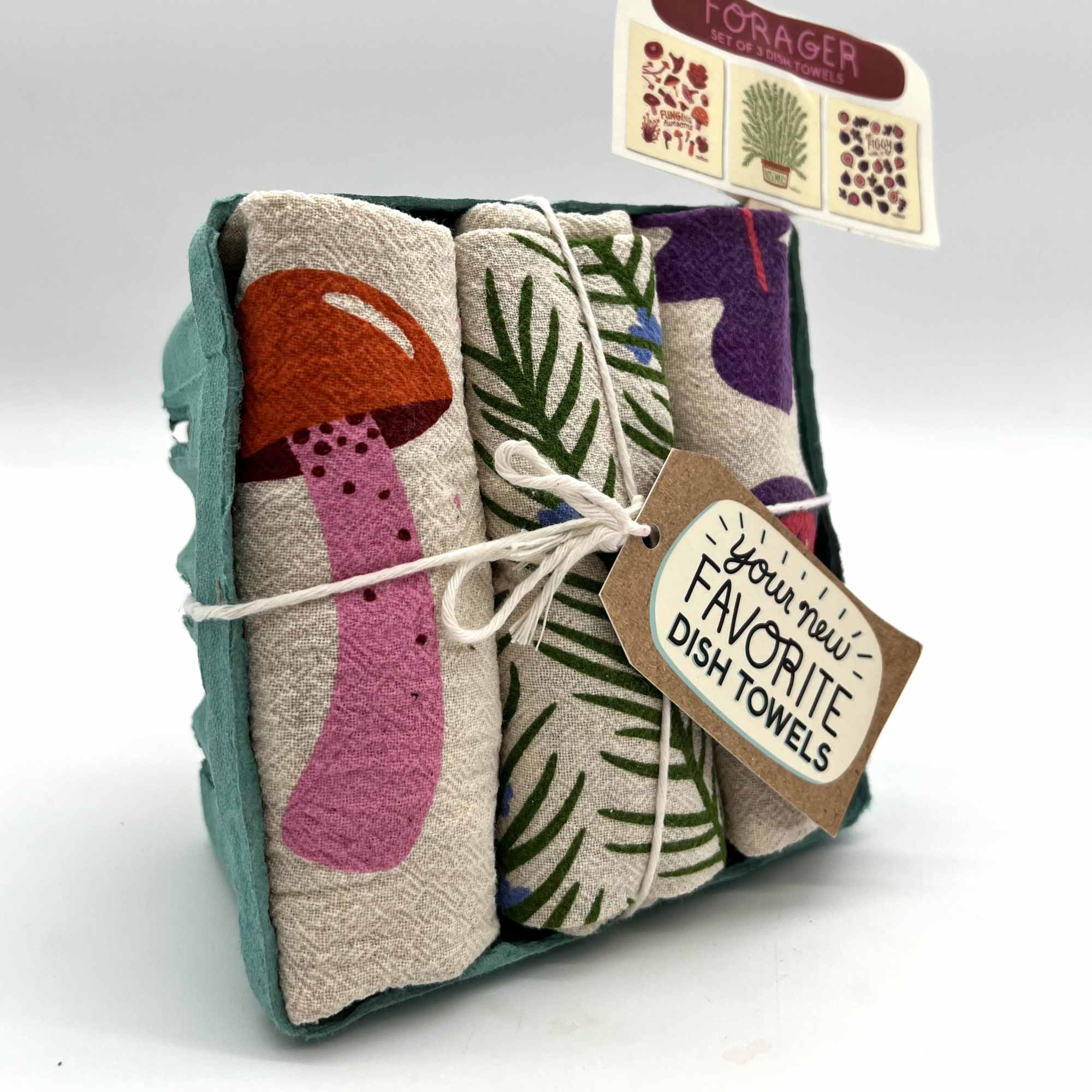 Set of three printed dish towels in a teal tray with mushroom and foliage designs