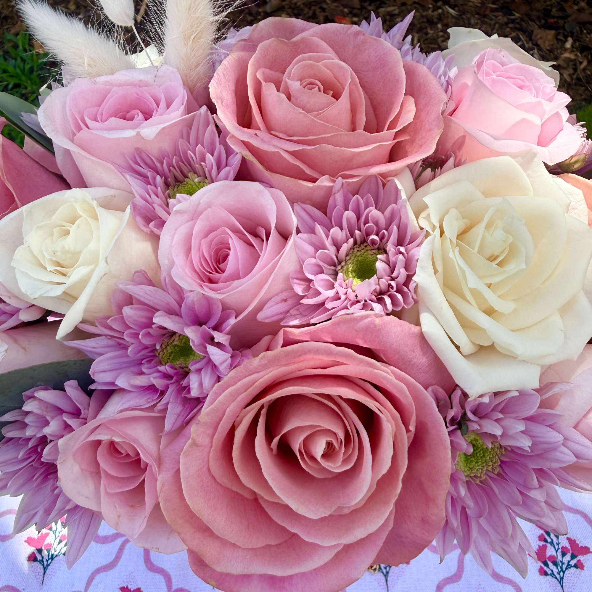 Pink and white roses with lavender daisies in a bouquet
