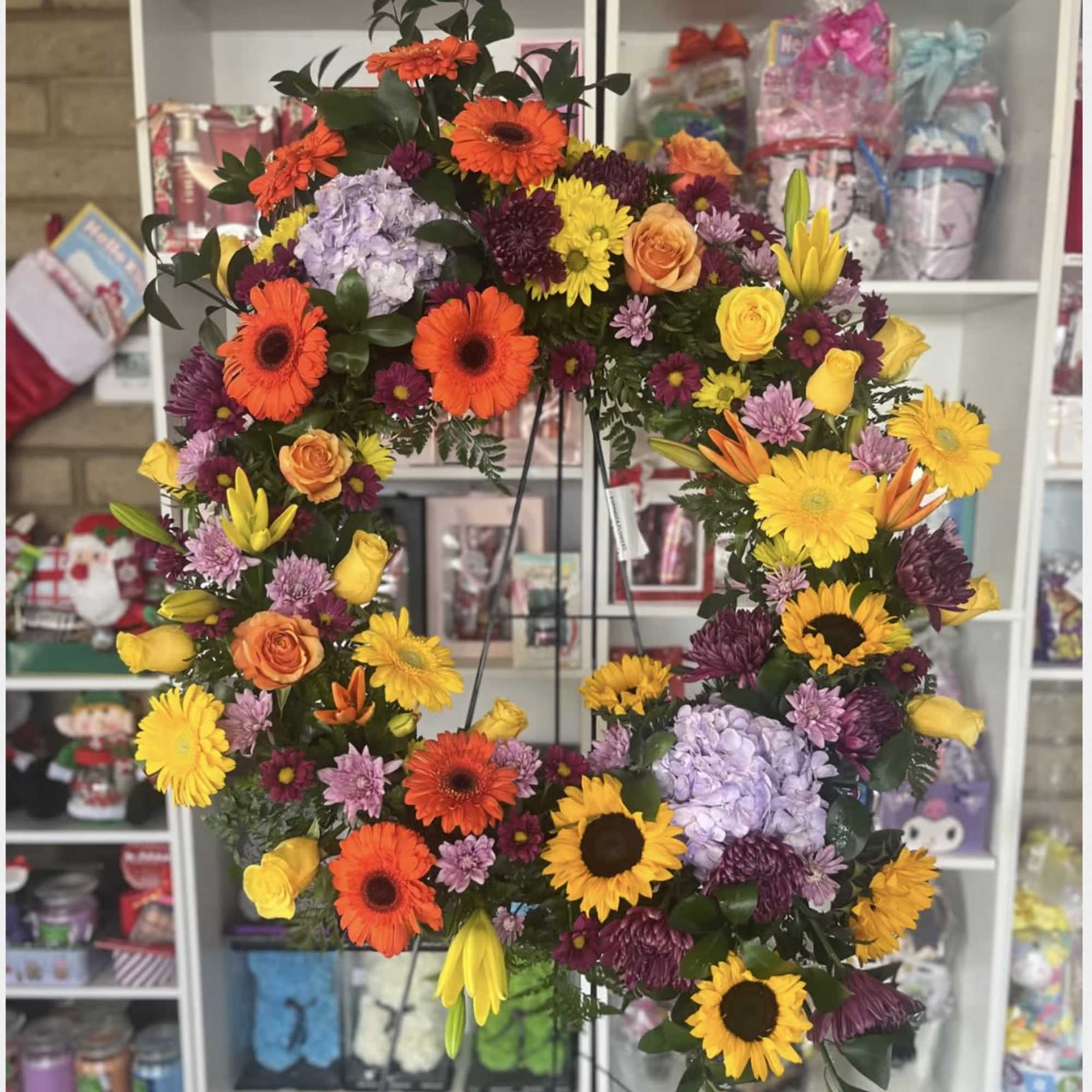 Large floral wreath on a stand with bright mixed blooms