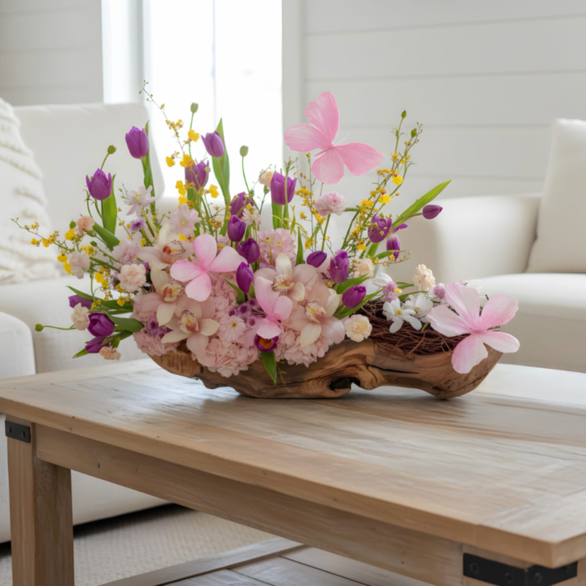 Pink hydrangeas, pink orchids and tulips with sunny yellow accents in a