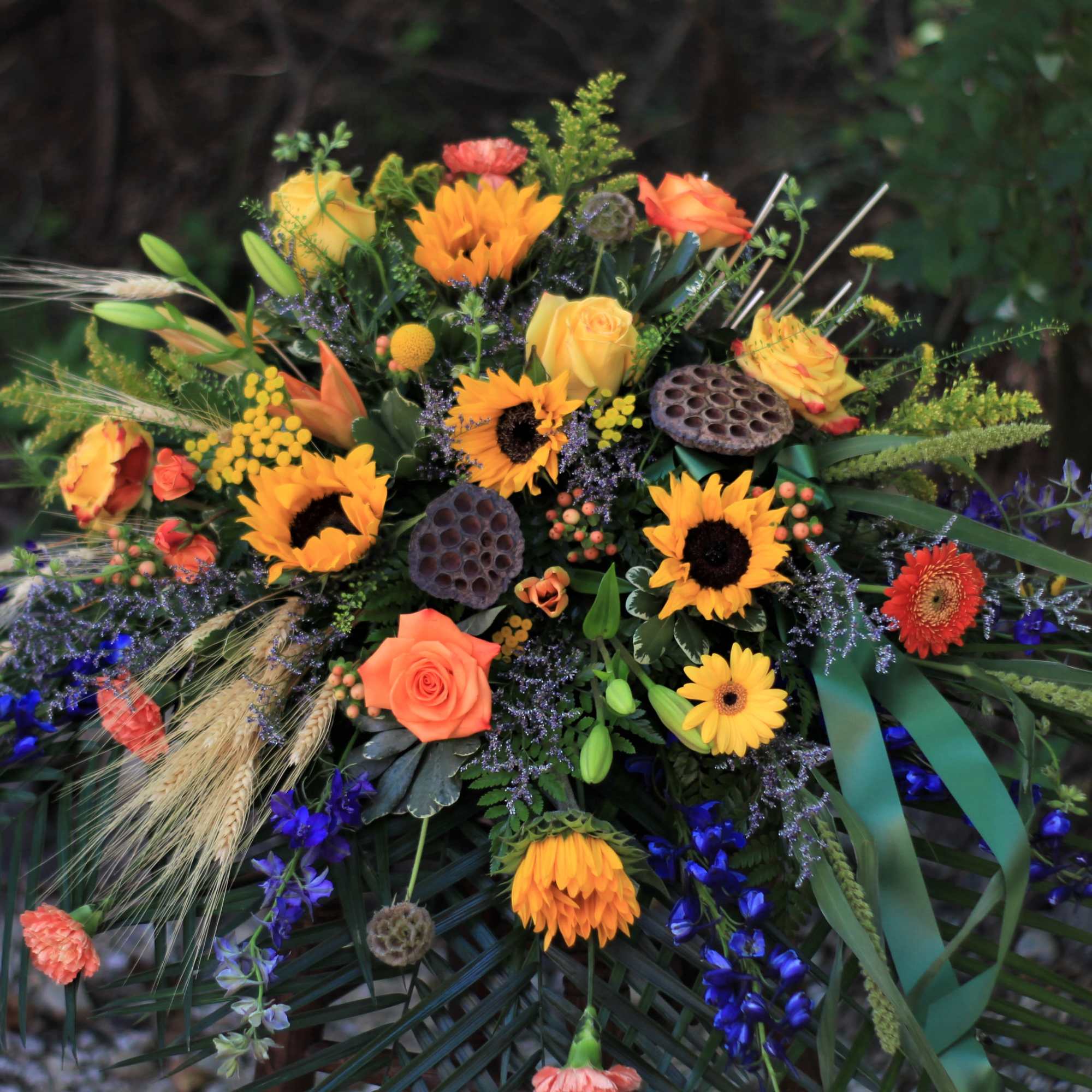 Colorful bouquet with sunflowers, orange roses, and blue flowers