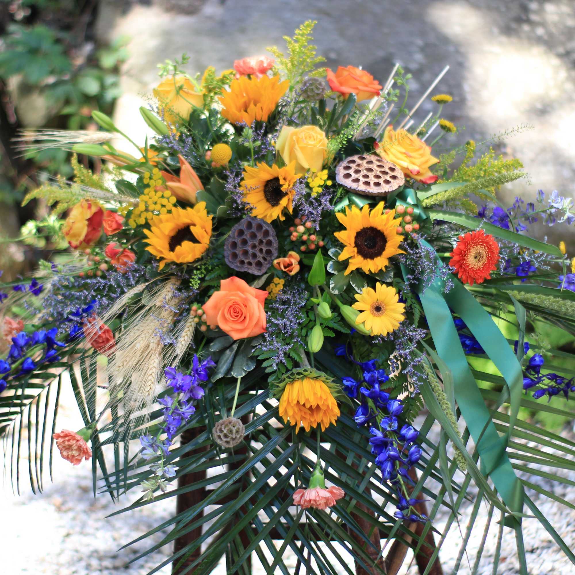 Colorful floral spray with sunflowers, roses, and blue flowers