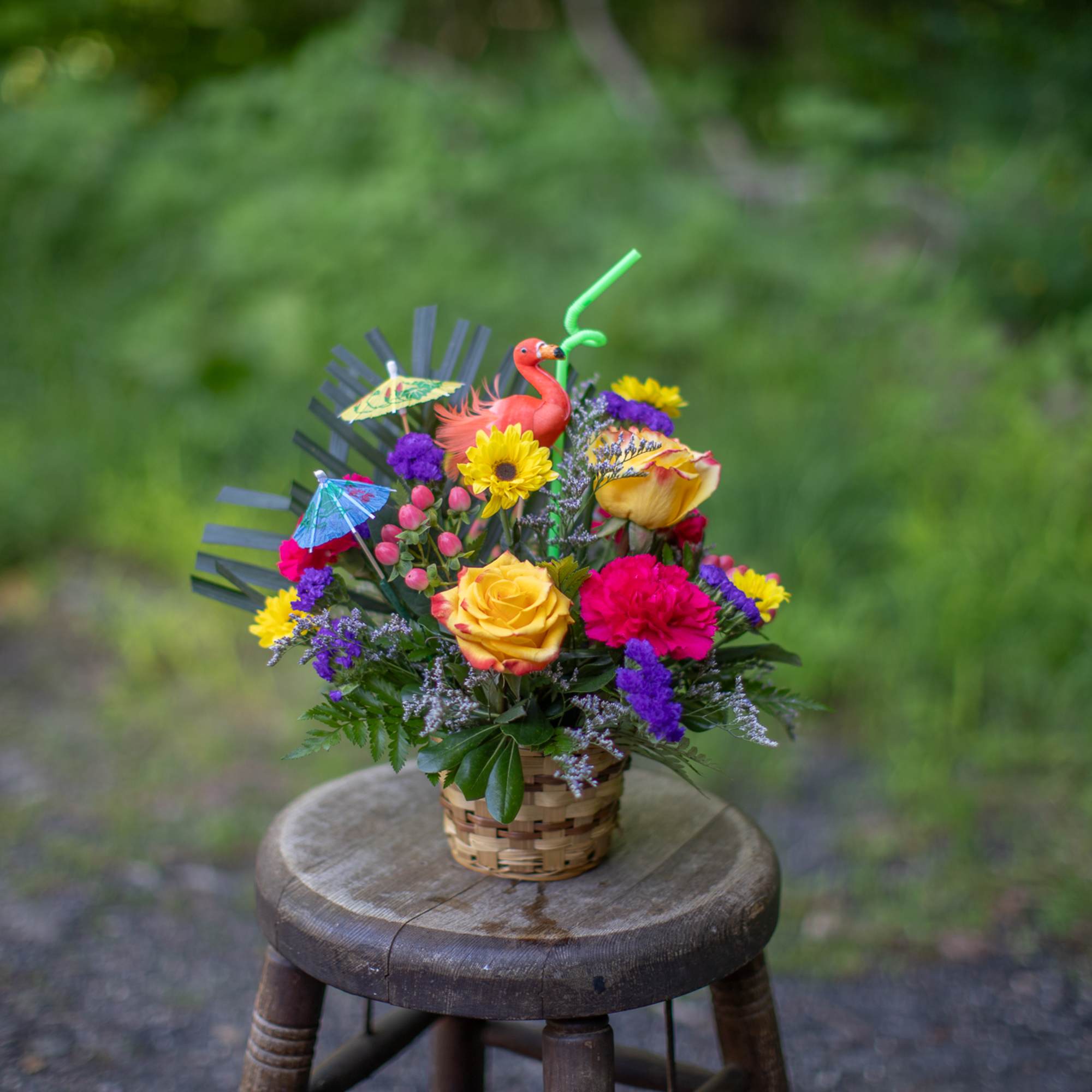 Colorful flower basket with roses, carnations, and a flamingo topper