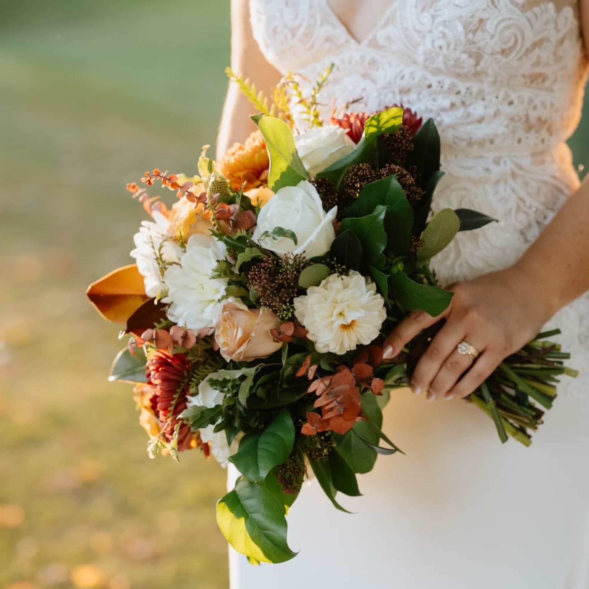Bride holding a bouquet of white, peach, and orange flowers