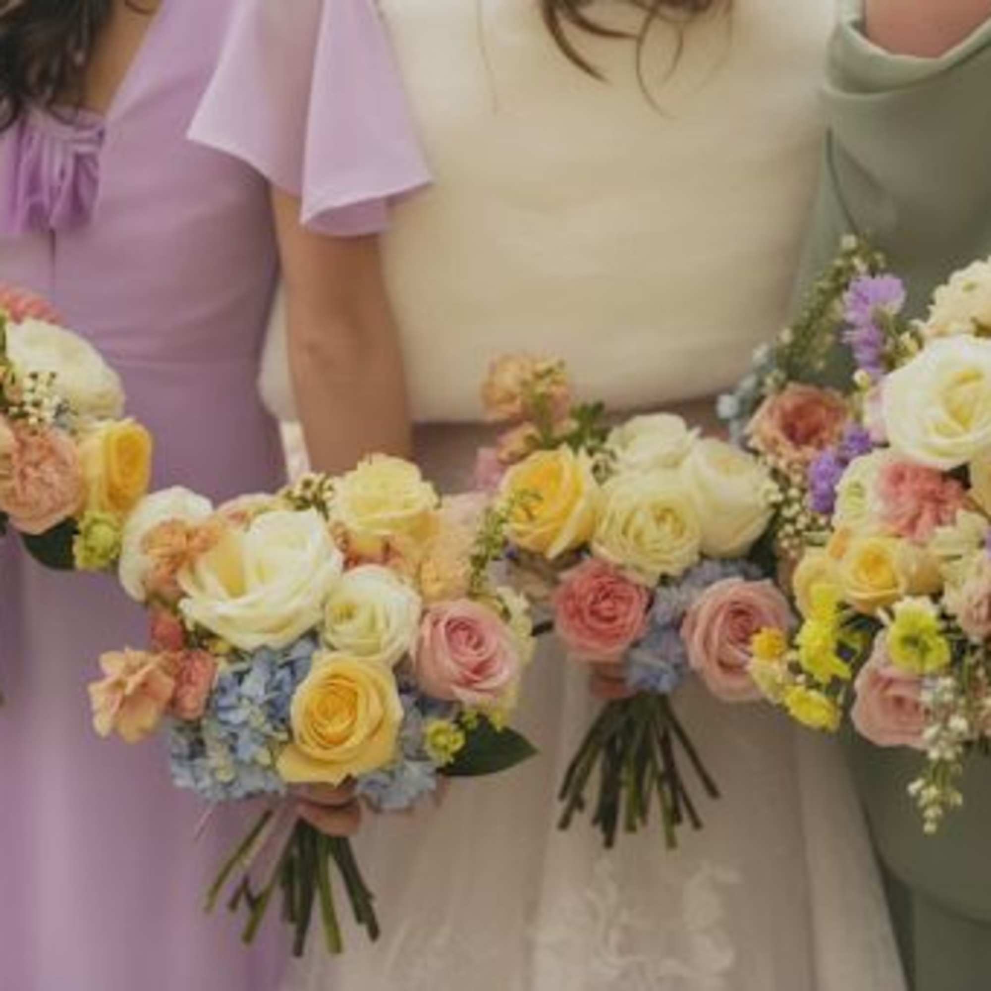 Bridesmaids holding pastel rose bouquets