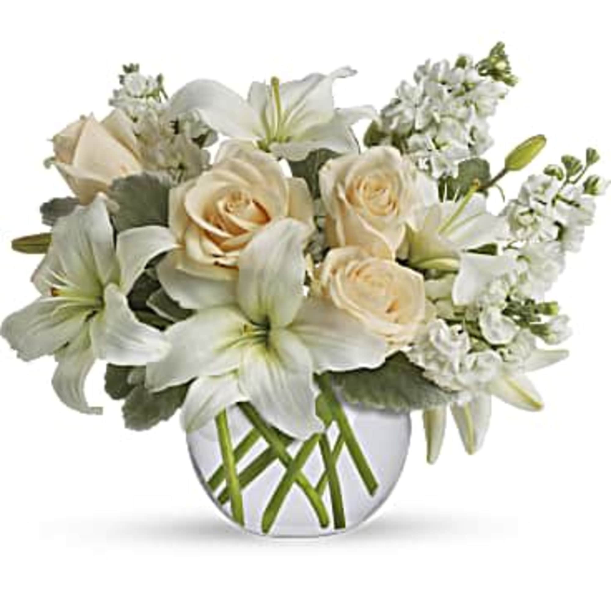 White lilies and cream roses arranged in a round glass vase