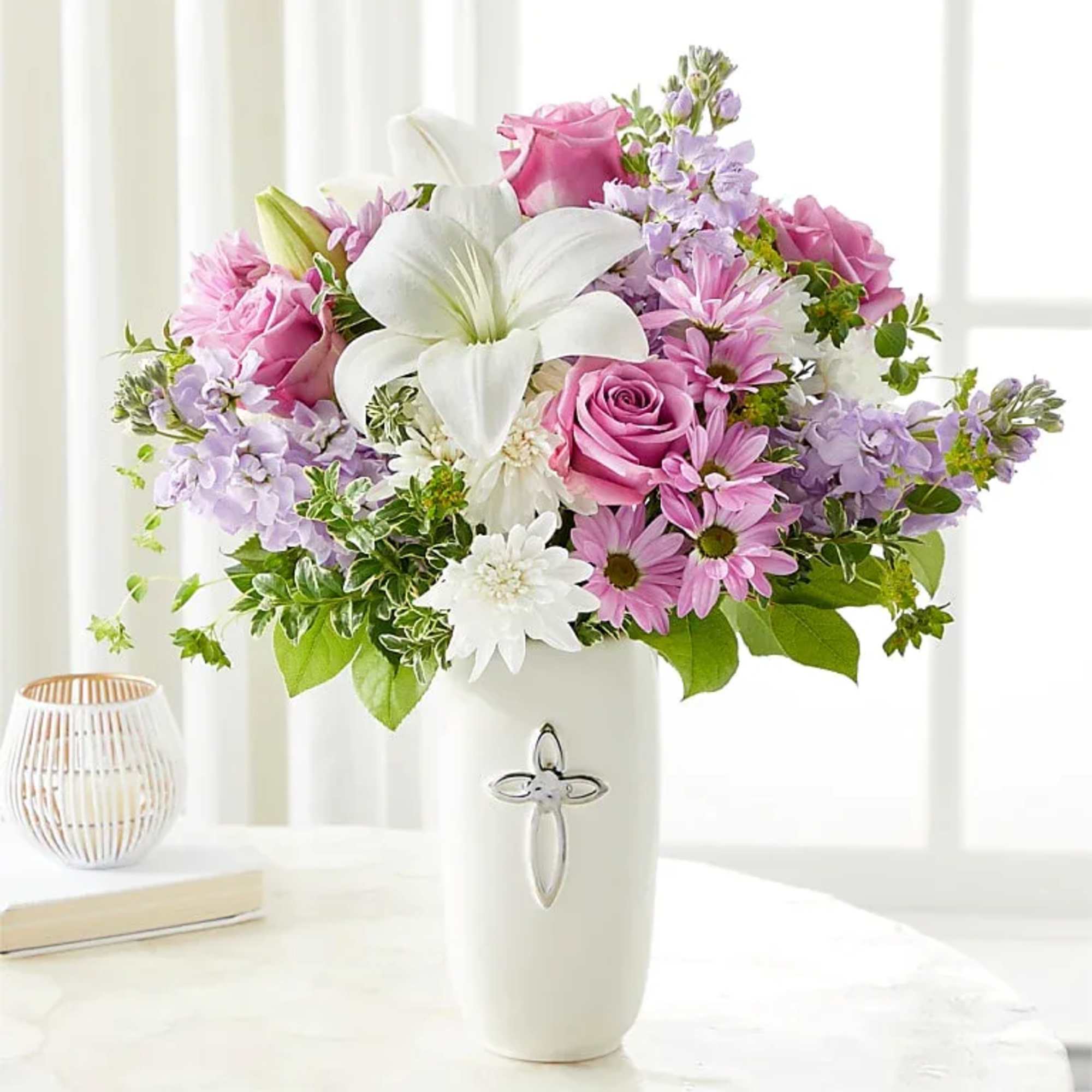 Pink and lavender bouquet with white lilies in a white vase
