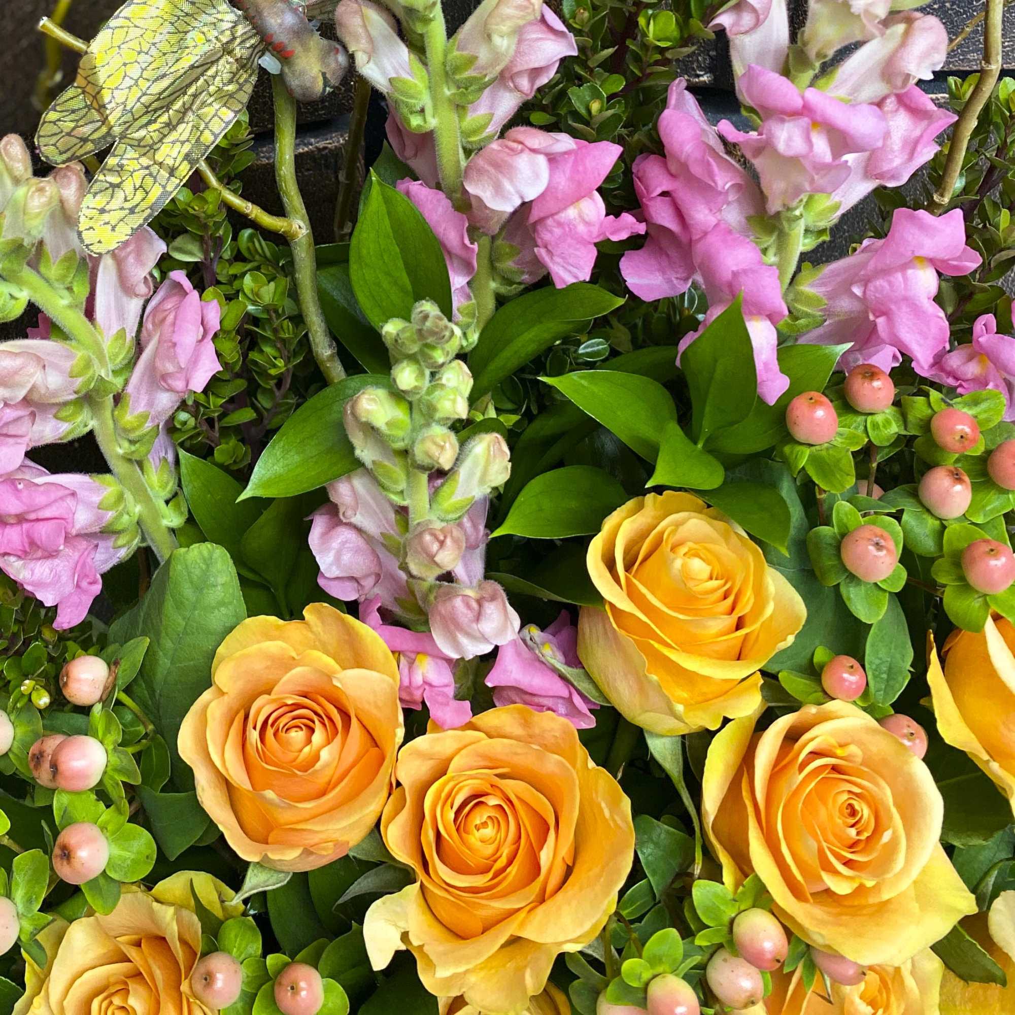 Pink snapdragons and yellow roses with berry accents