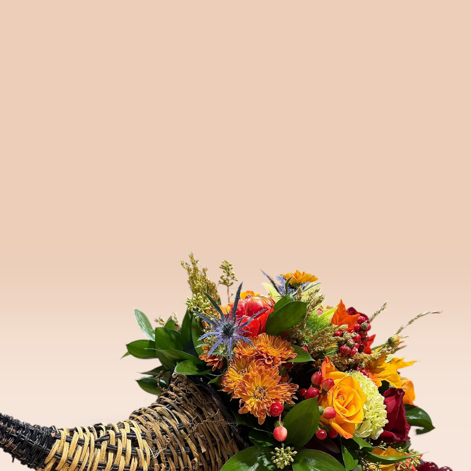 Horn-shaped basket arrangement with orange, yellow, red, and blue flowers
