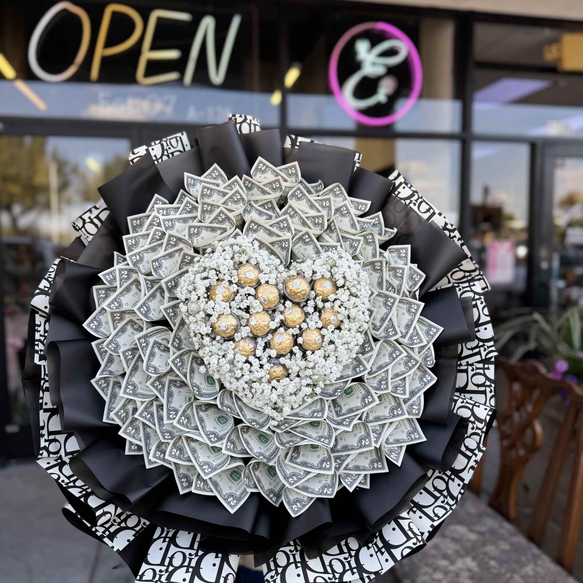 Large bouquet made of dollar bills with white filler flowers and gold chocolates