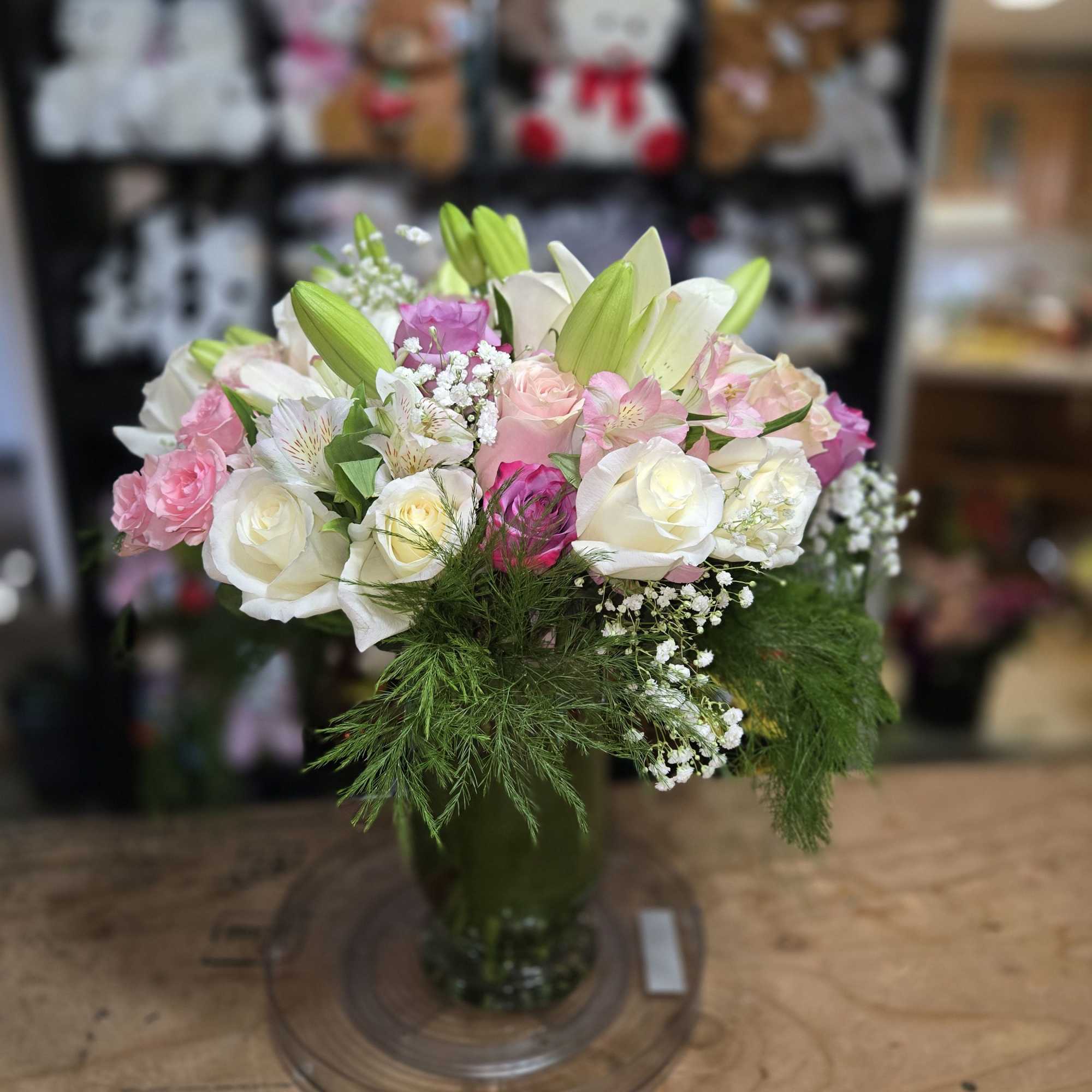 Pink and white bouquet with lilies and roses in a glass vase