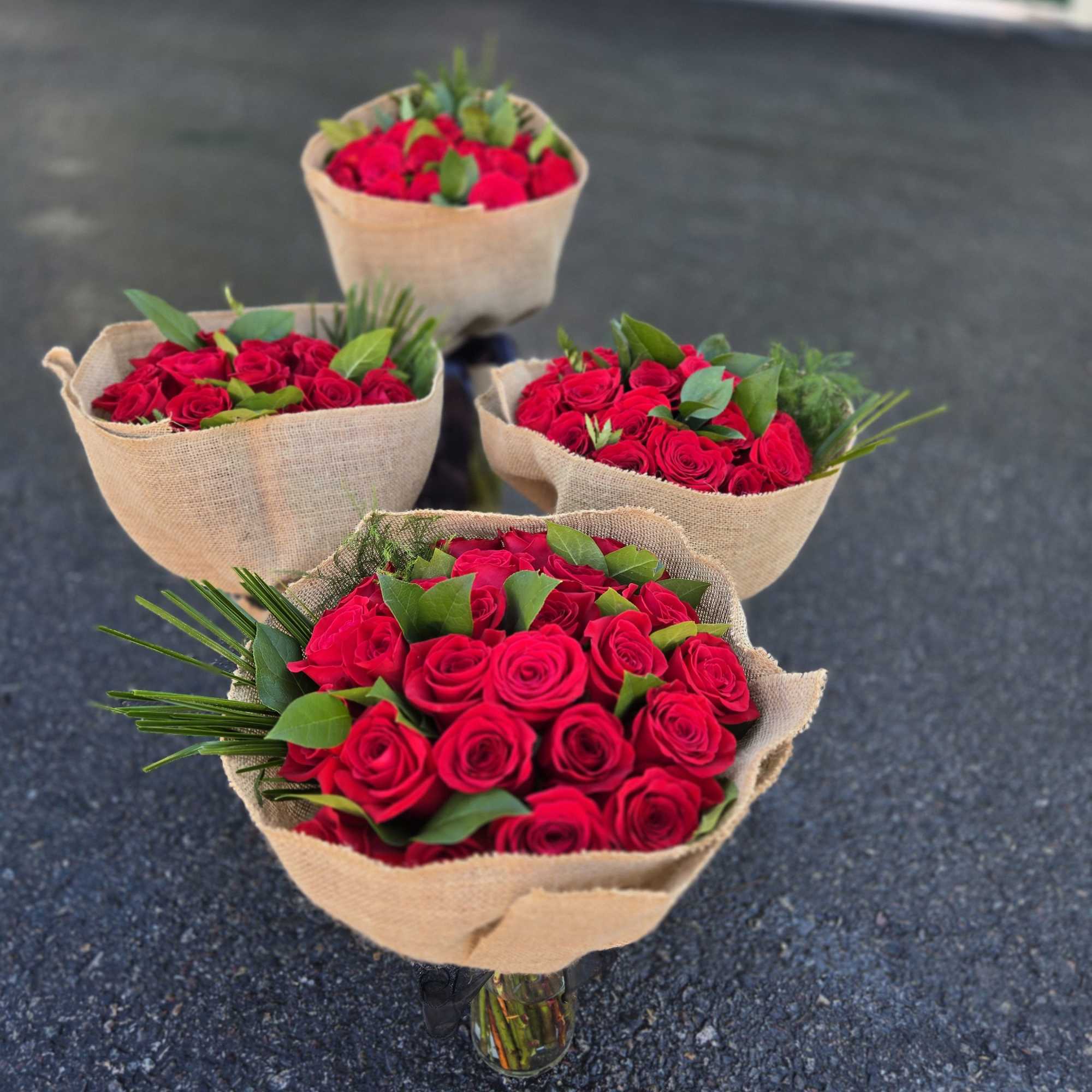 Four bouquets of red roses wrapped in burlap