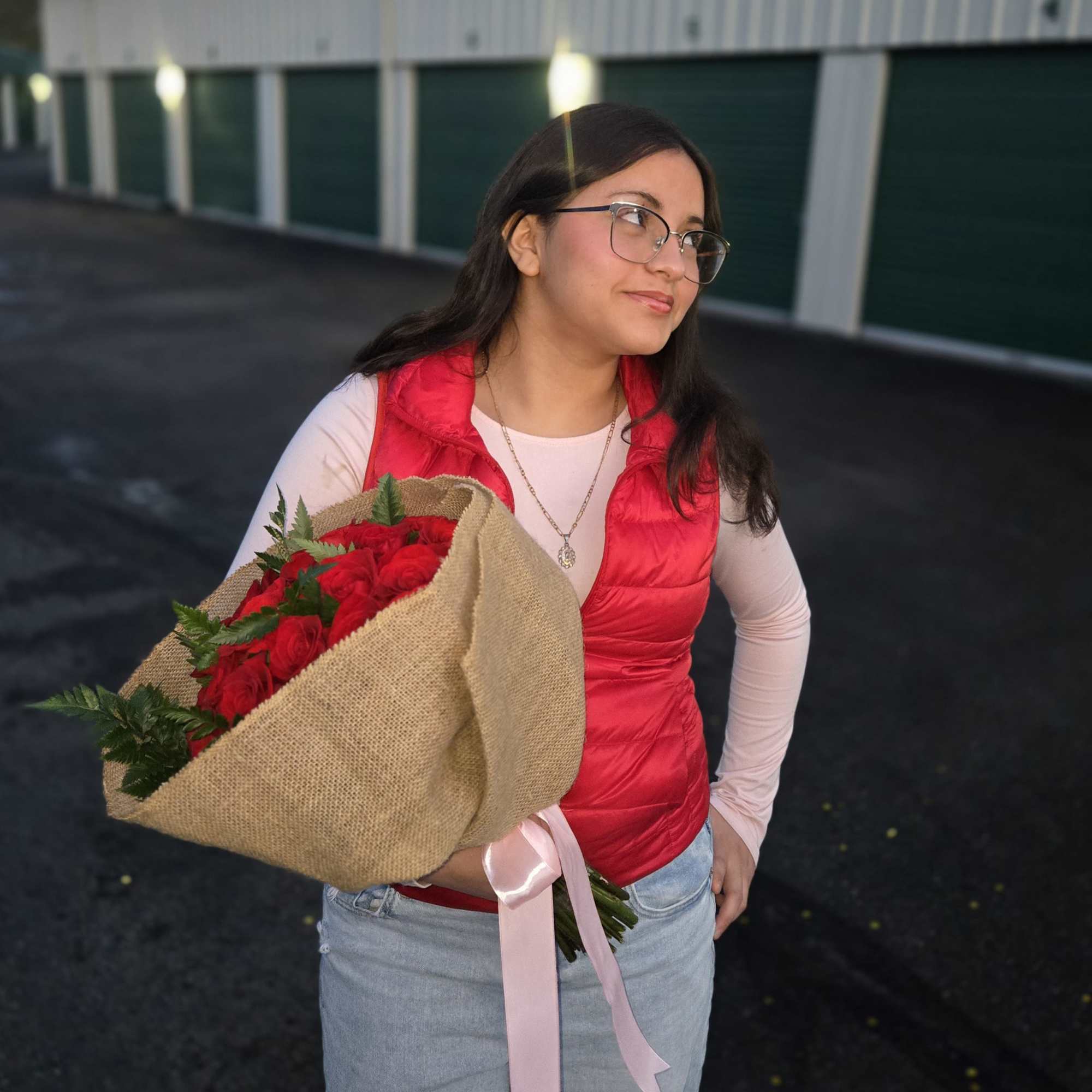 Woman holding a bouquet of red roses wrapped in burlap