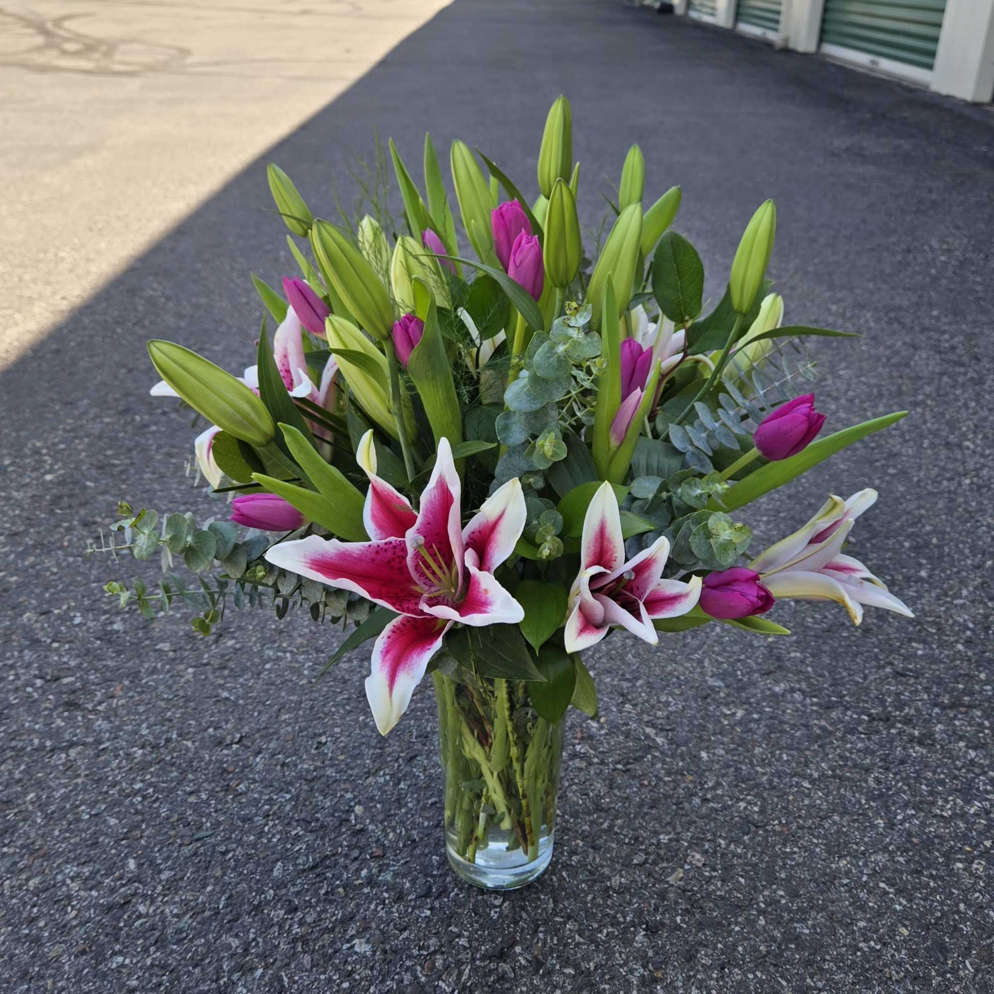 Bouquet of pink and white lilies in a clear glass vase