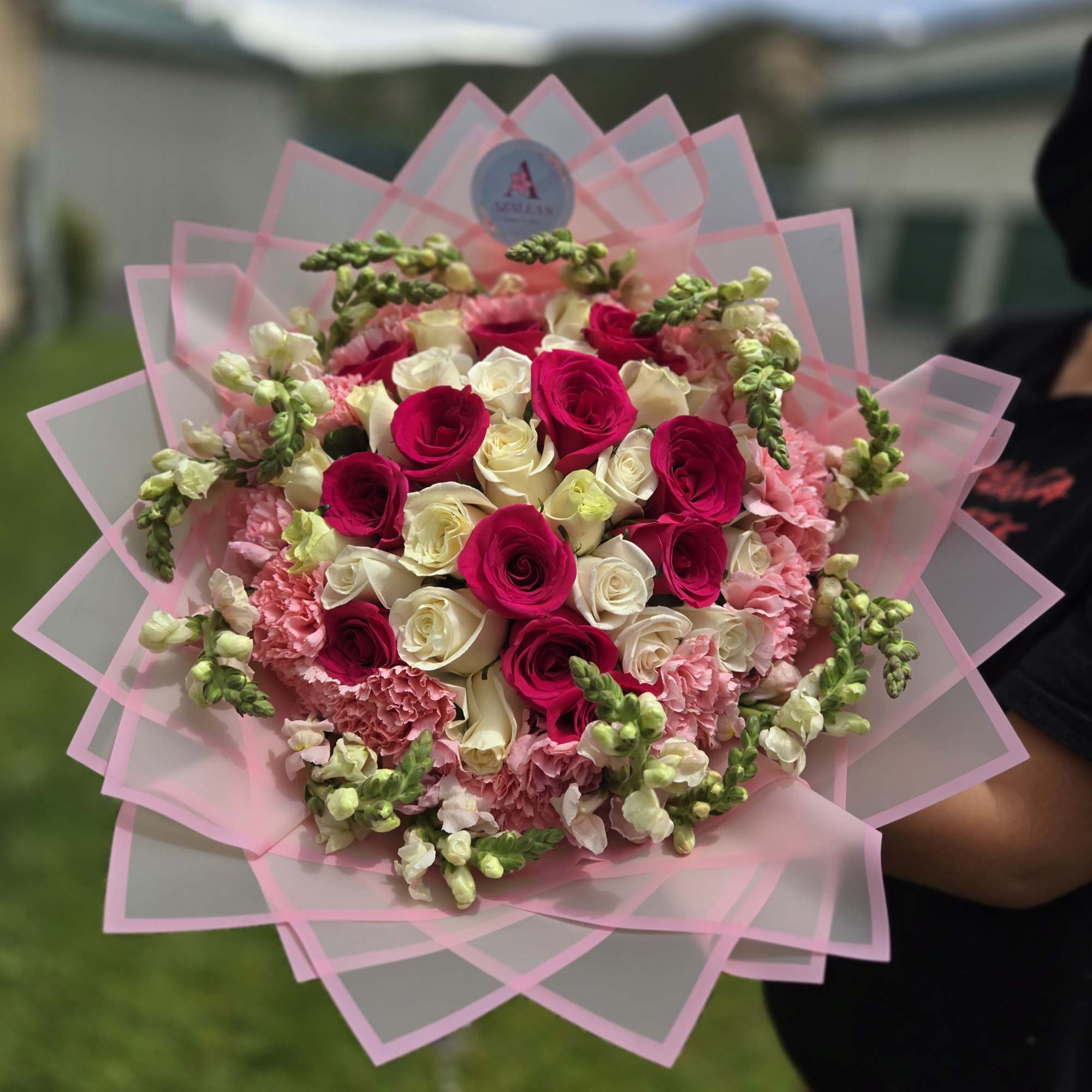 Bouquet of pink and white roses with pink carnations wrapped in pink paper