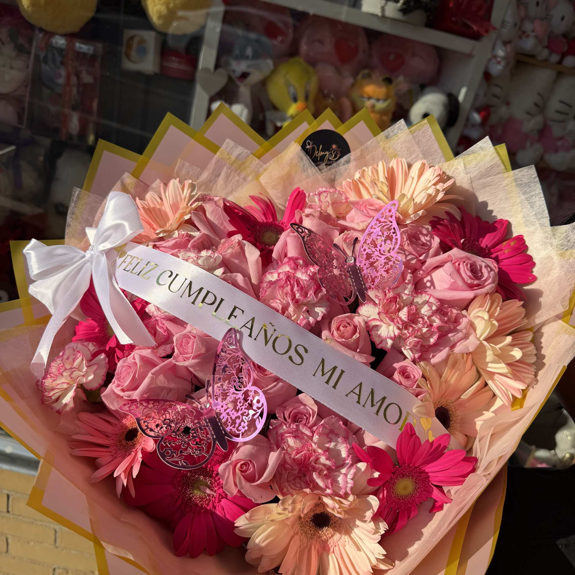 A BEAUTIFUL WRAPPED BOUQUET MIXED WITH DIFFERENT SHADES OF PINK WHITE AN