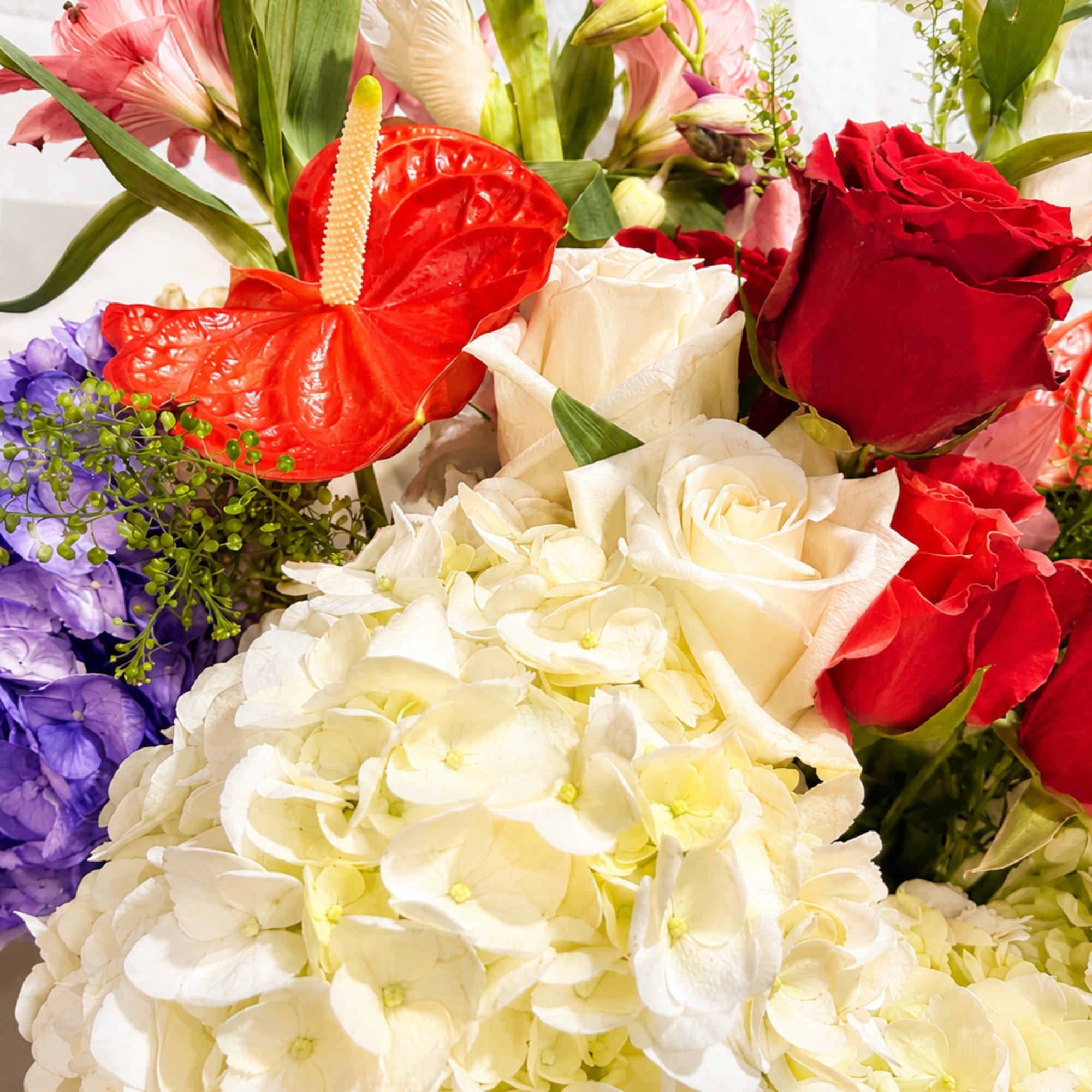 Mixed bouquet with white hydrangeas, red roses, and anthuriums