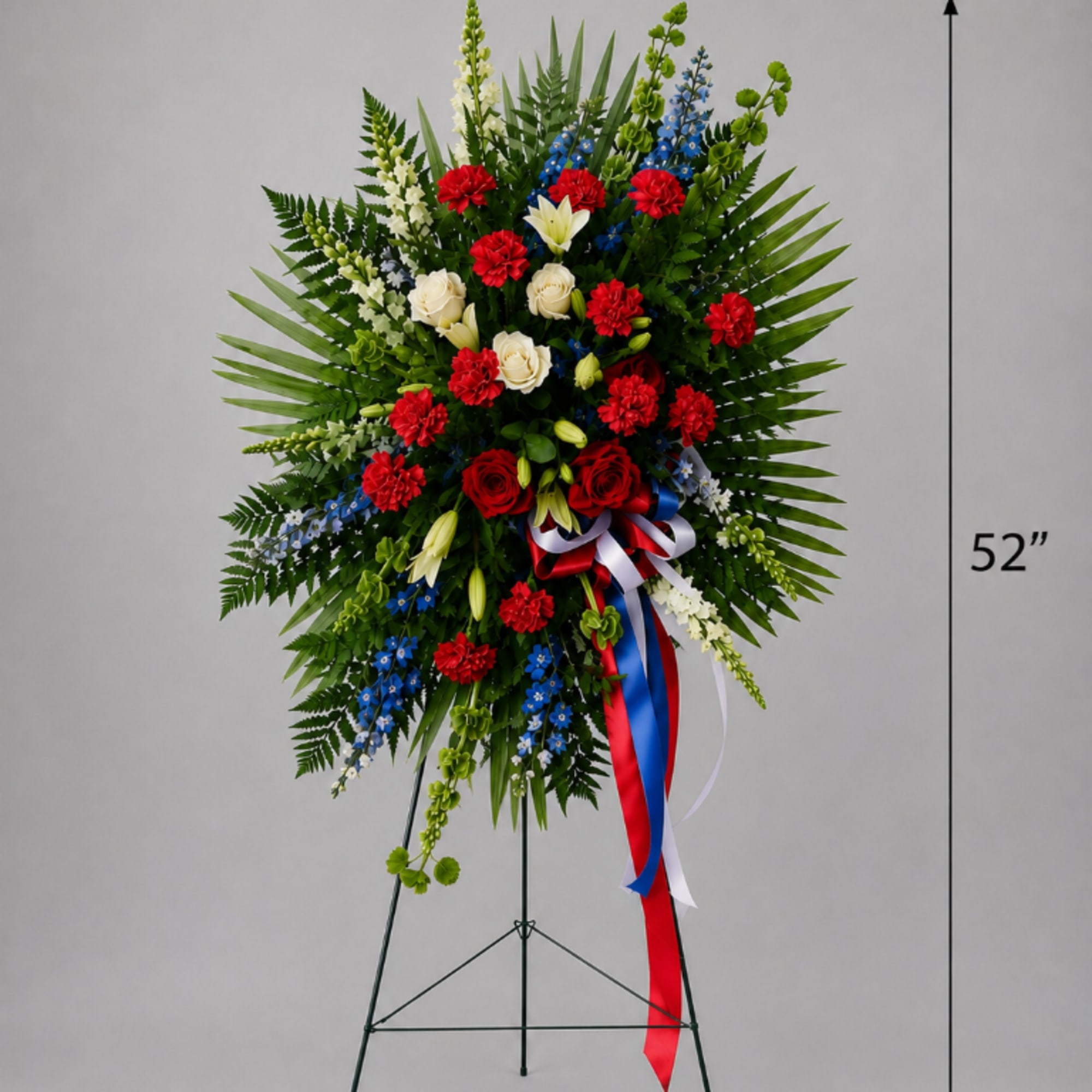 Tall standing floral wreath with red, white, and blue flowers on an easel