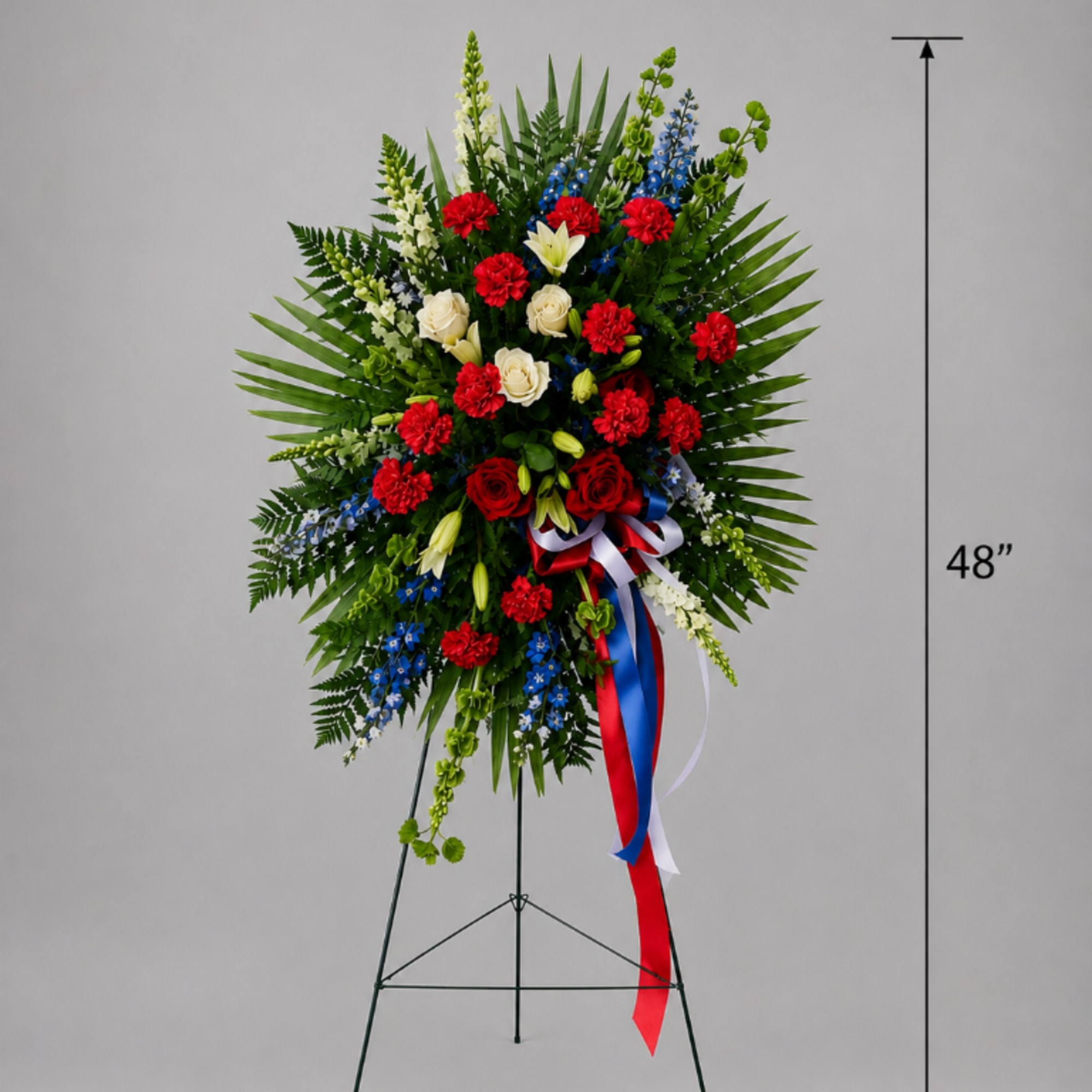 Tall standing floral spray with red, white, and blue flowers on a metal easel